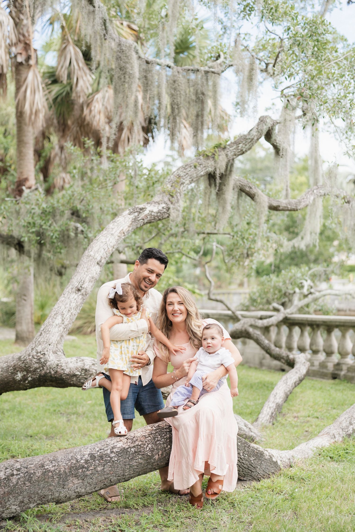 Family beneath moss-draped oaks at golden hour, photographed by Upswing Photography
