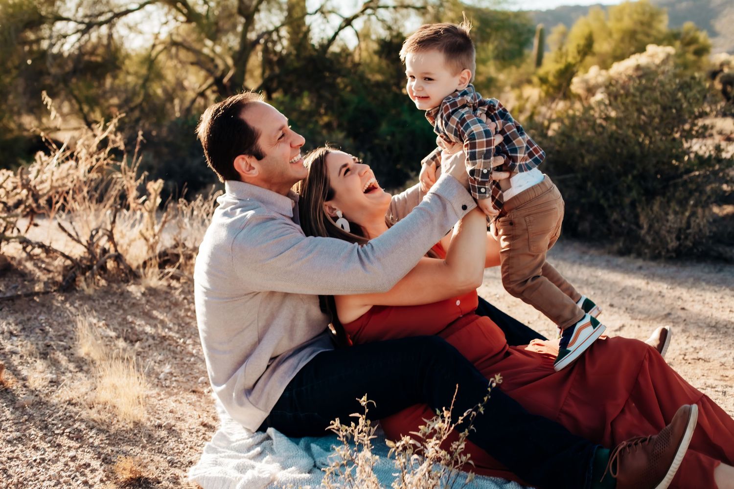A joyful family moment captured outdoors during golden hour in a natural setting.