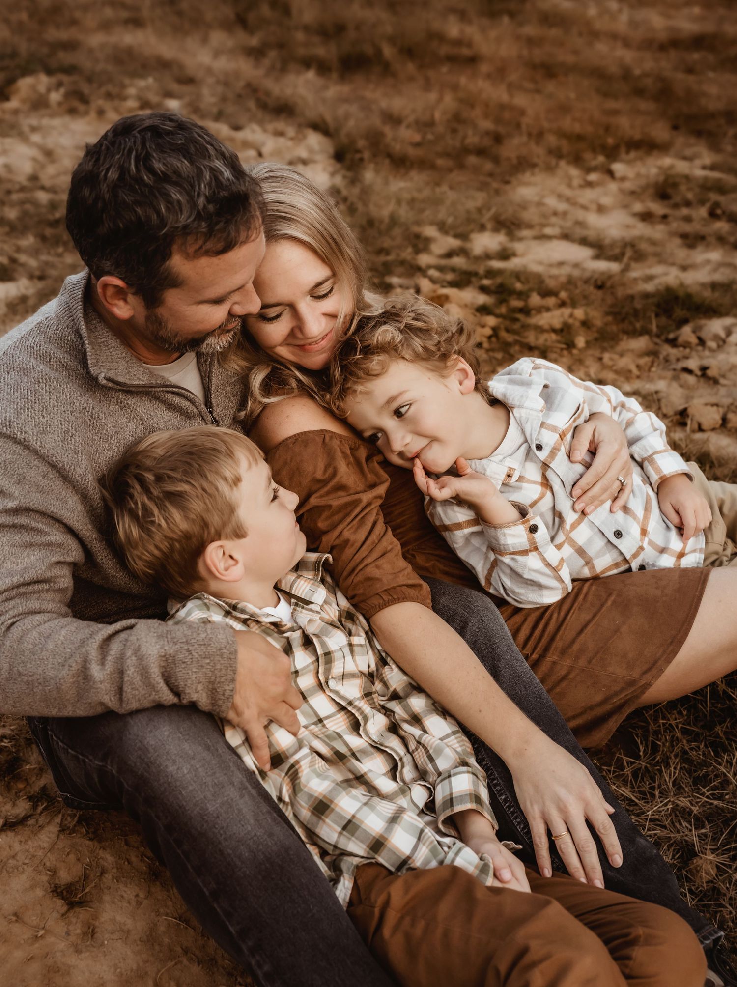 Family shares intimate moment together during outdoor portrait session.
