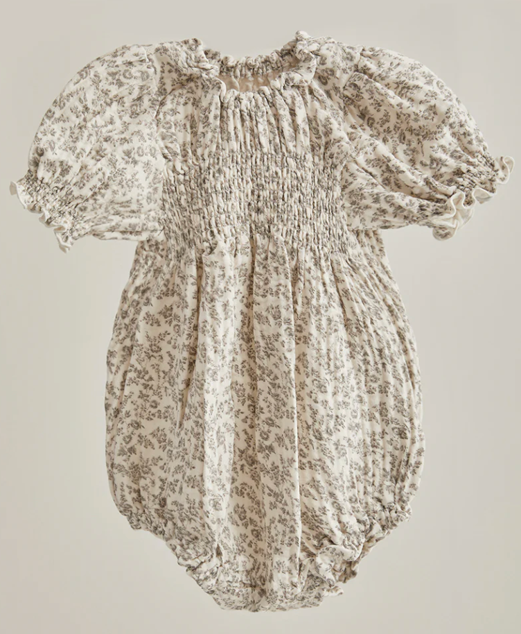 Baby girl floral smocked romper with puff sleeves and balloon hem in cream and taupe ditsy print.