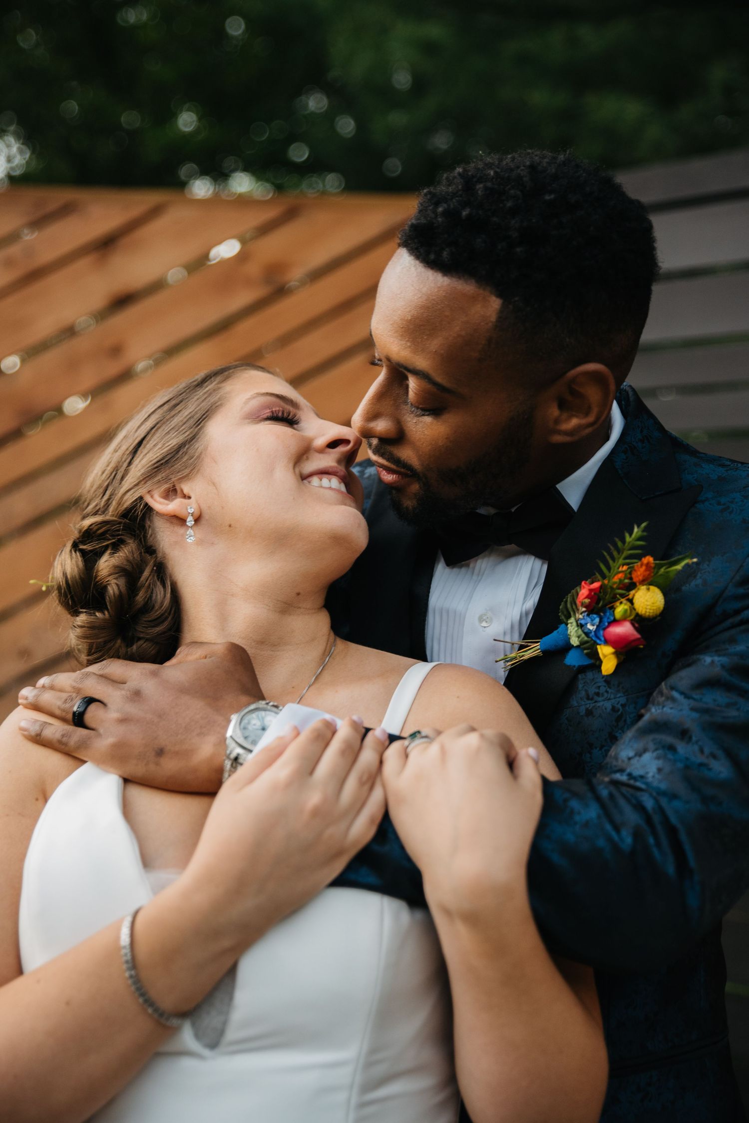 Intimate moment between newlyweds during outdoor wedding photoshoot.