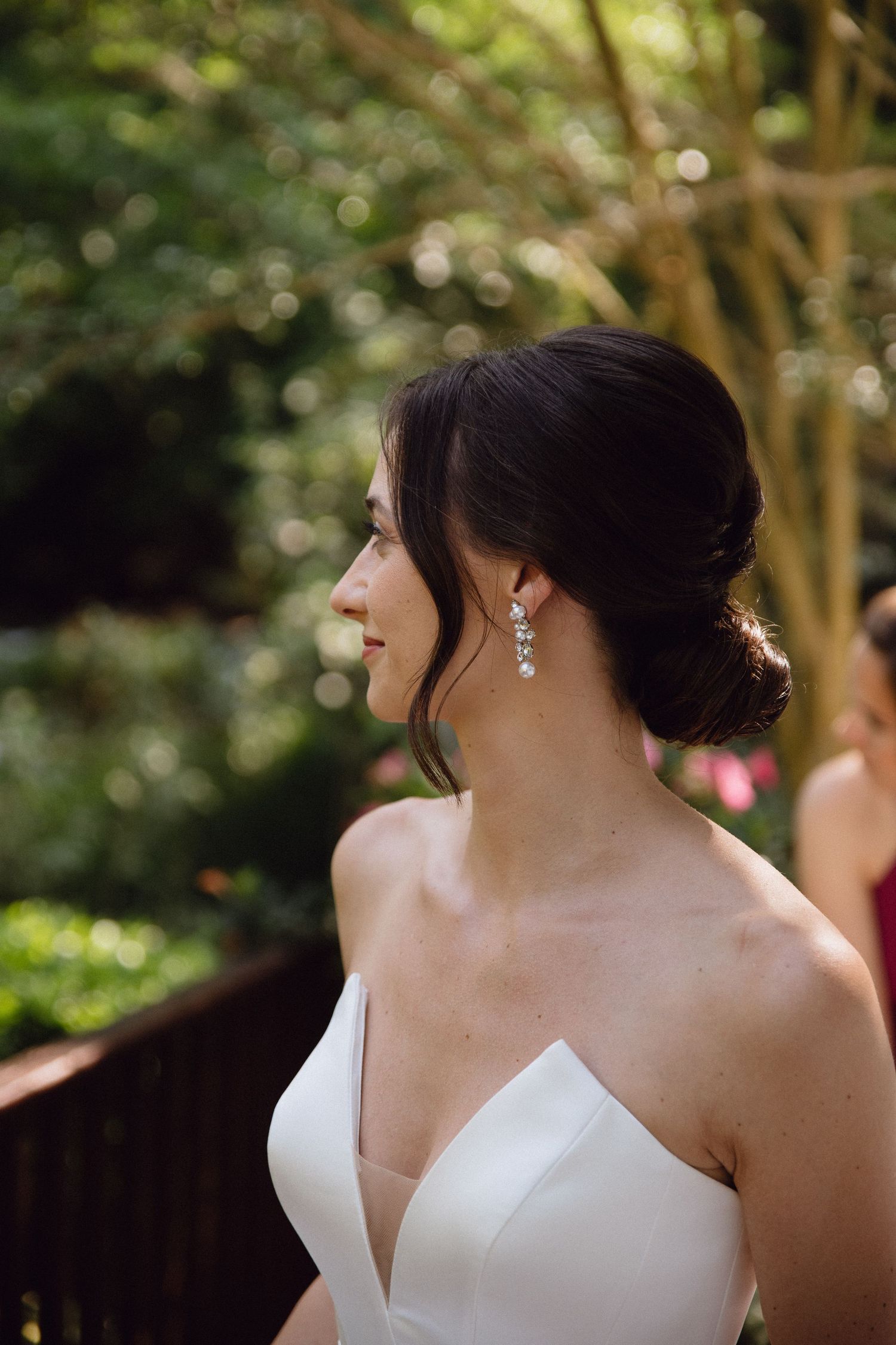 Elegant bride in white dress with updo hairstyle and sparkling earrings.