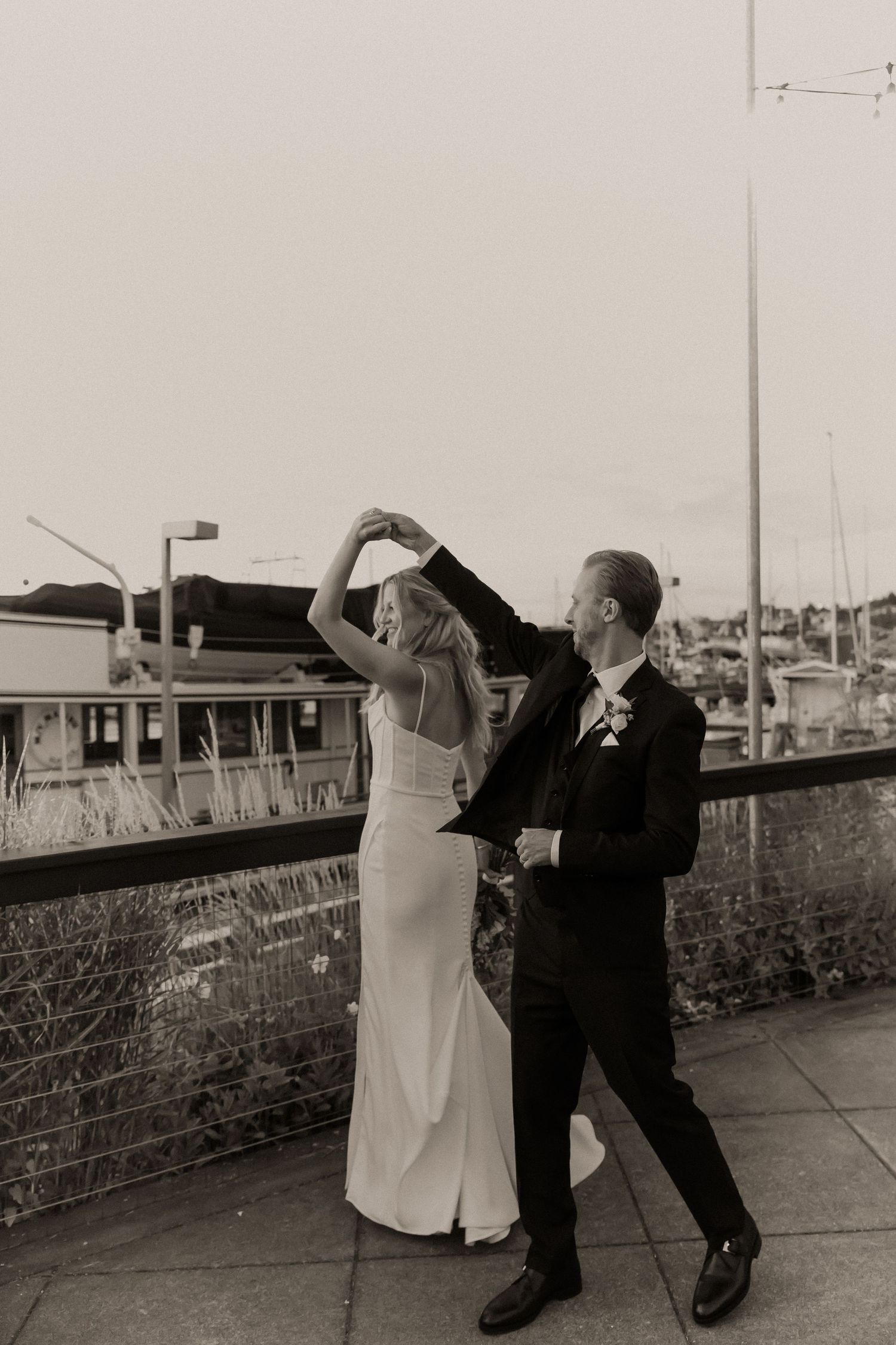 A playful couple dancing and posing on an outdoor terrace.