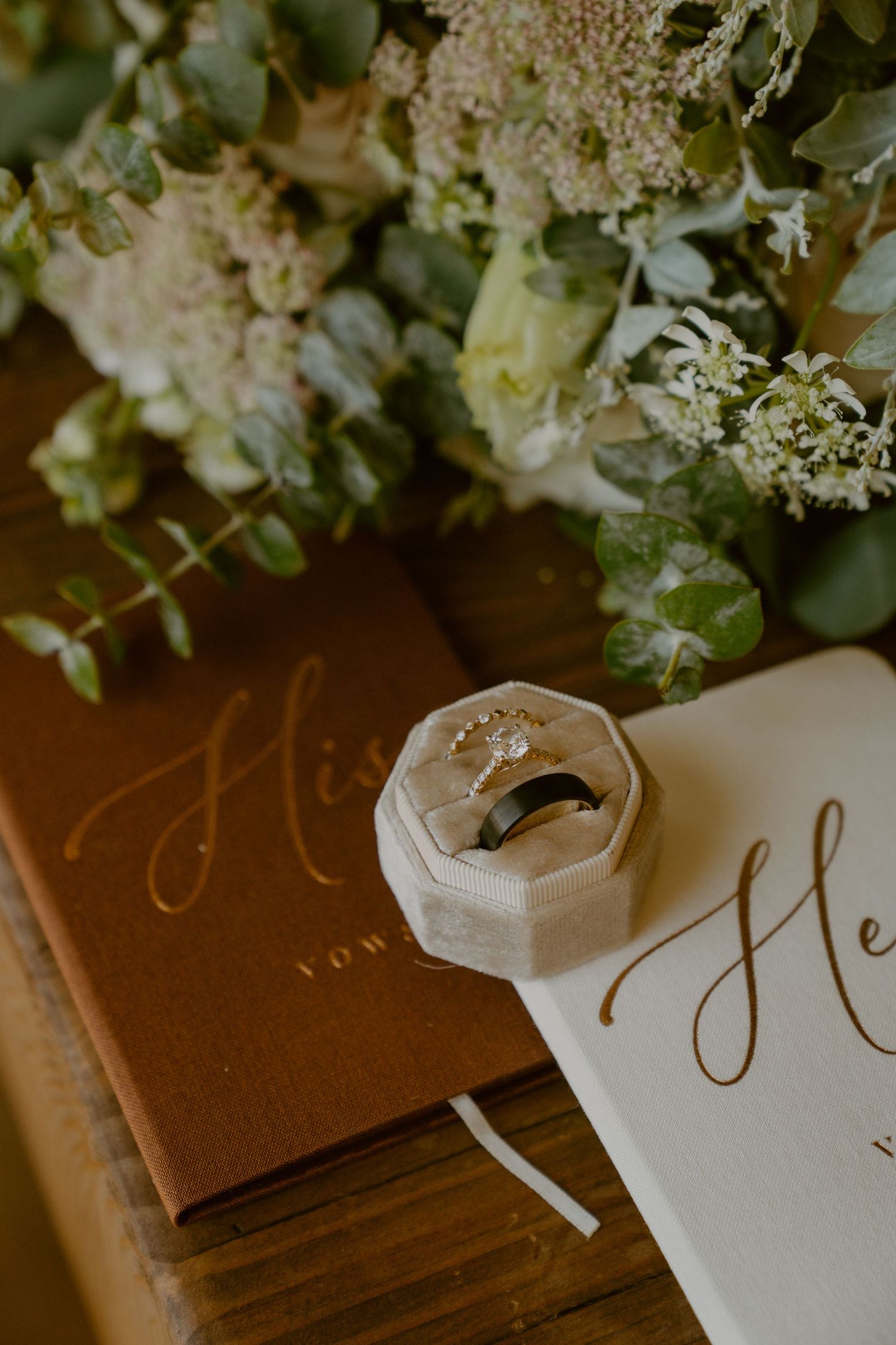 Elegant wedding details with white hydrangea flowers and calligraphy on brown paper with wax seal accents.