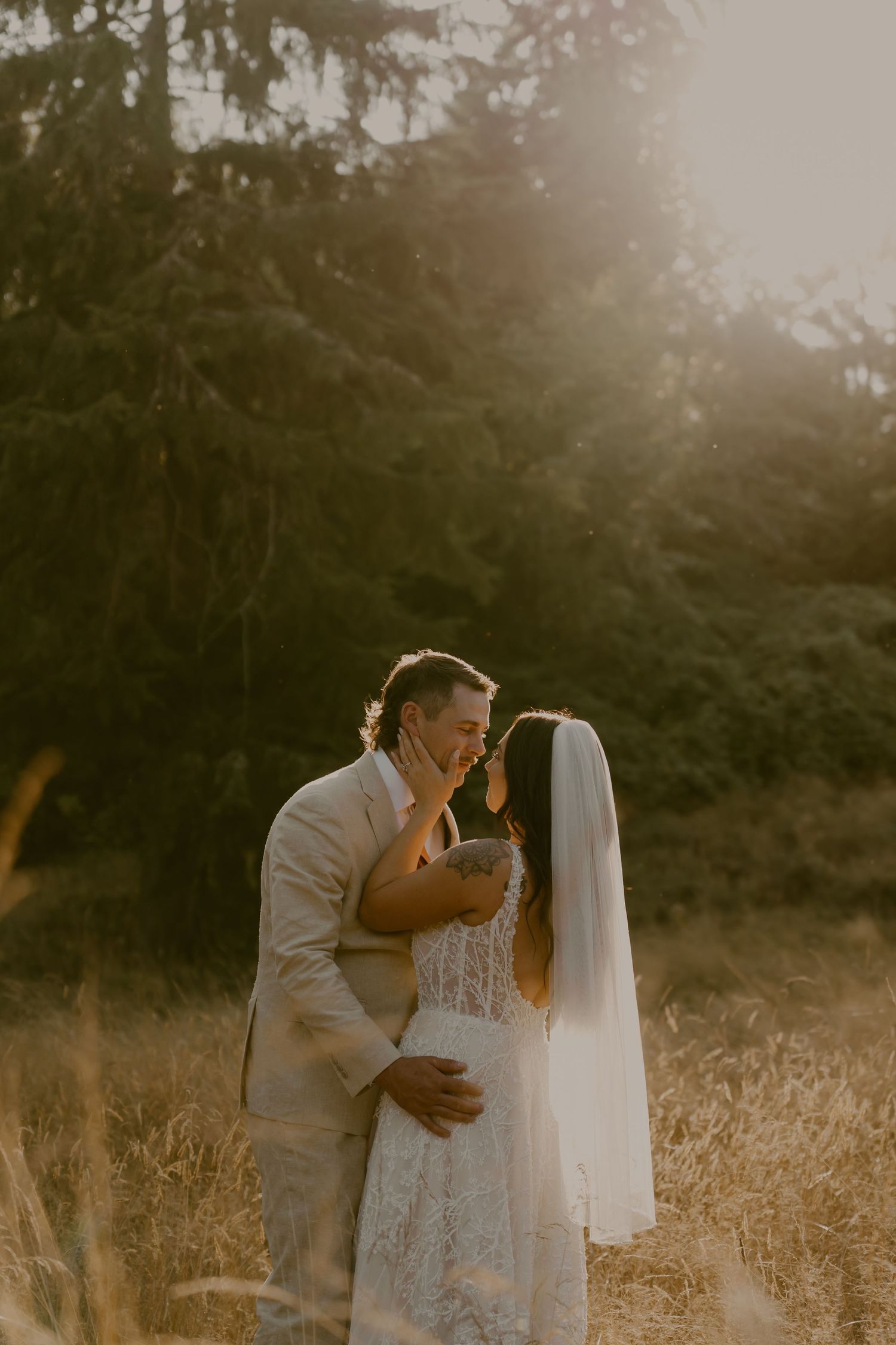 A romantic sunset portrait of a couple embracing in a golden field.