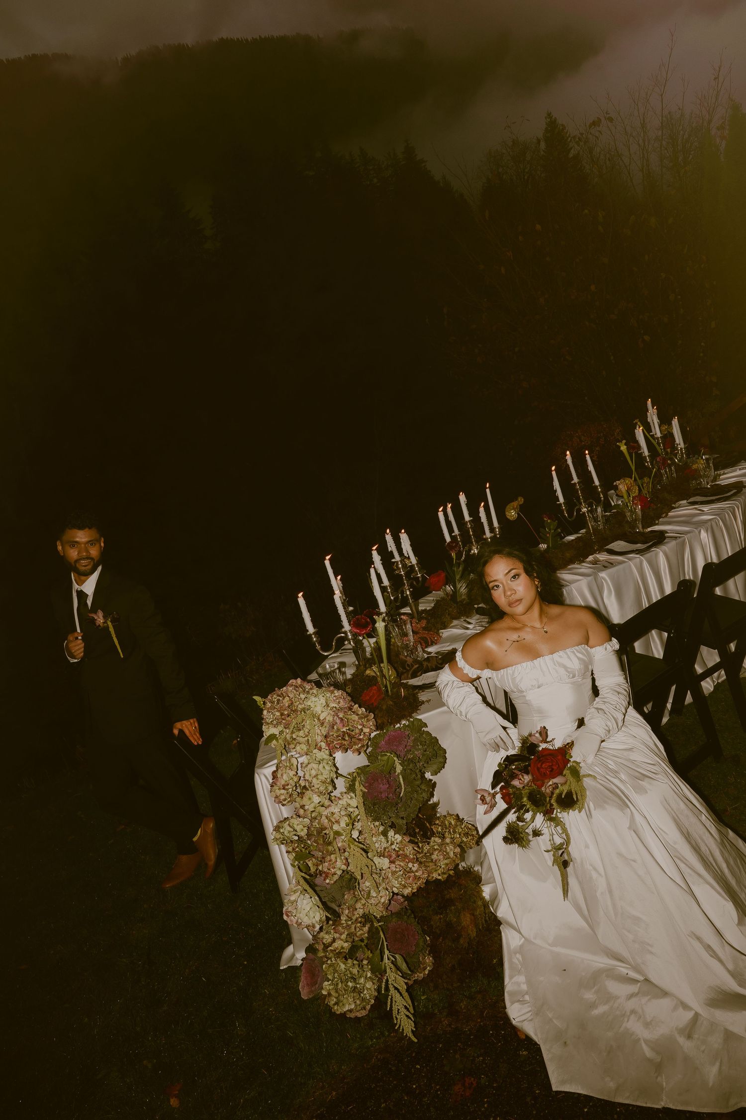 A sequence of wedding photos showing the bride in a white gown laying down with floral arrangements in a dark setting.