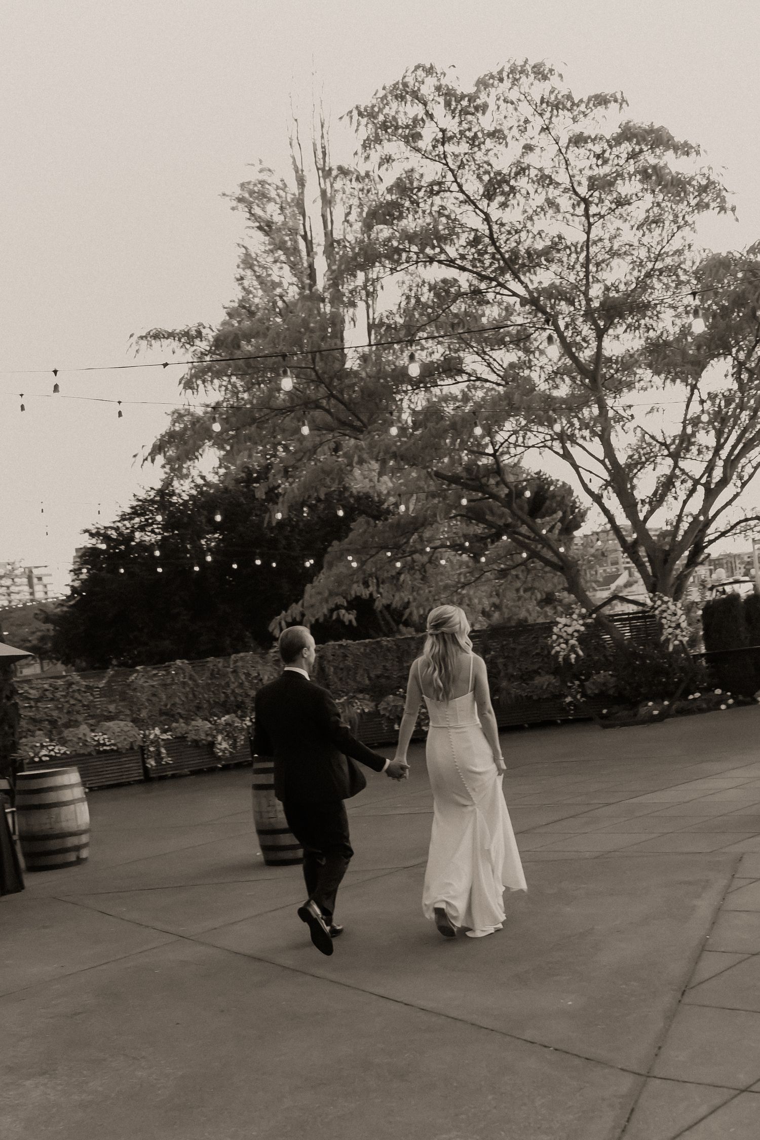 A couple dancing together on an outdoor patio in black and white.