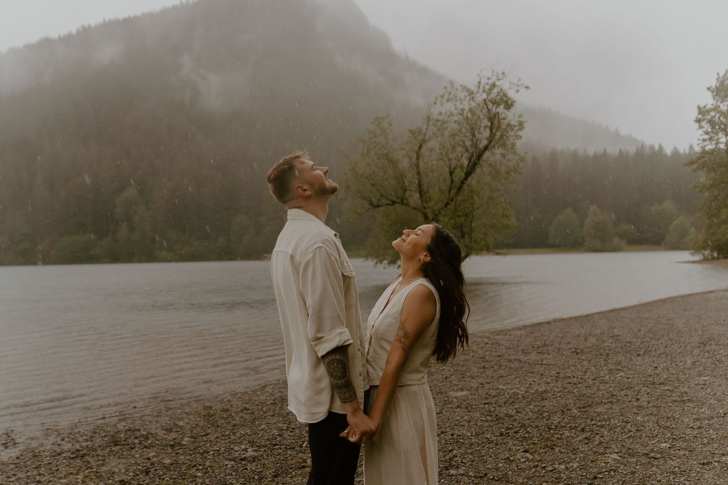 Romantic scene by a misty lake with mountains creating a dramatic backdrop.