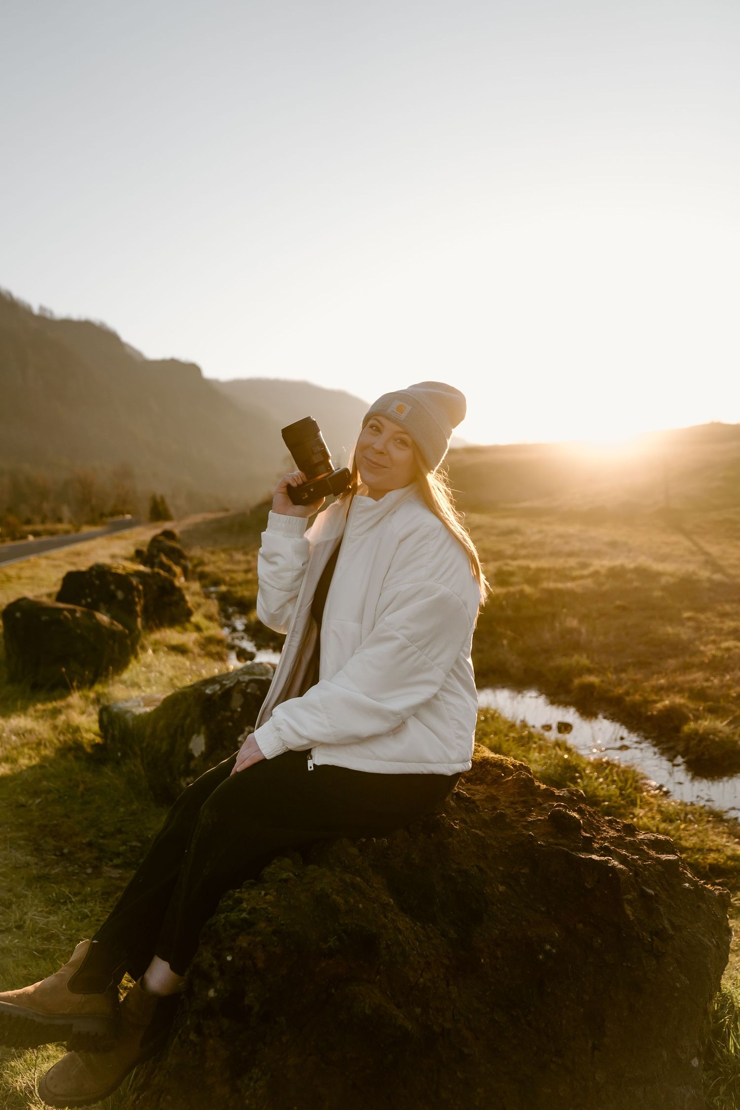 Romantic sunset photoshoot on rocky coastal cliffs with warm golden light illuminating the scenic landscape.