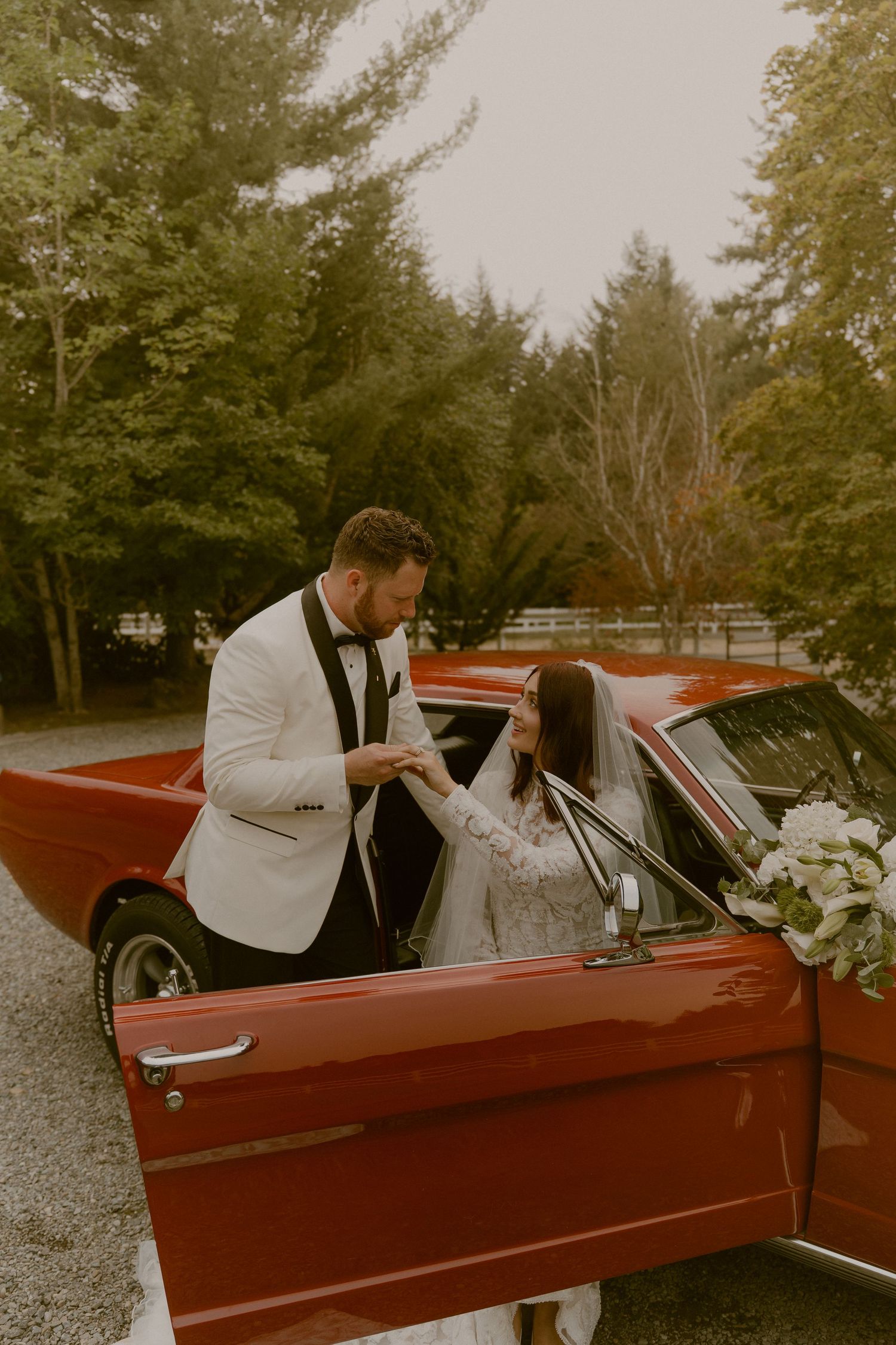 A couple sharing a moment in a classic red convertible car.