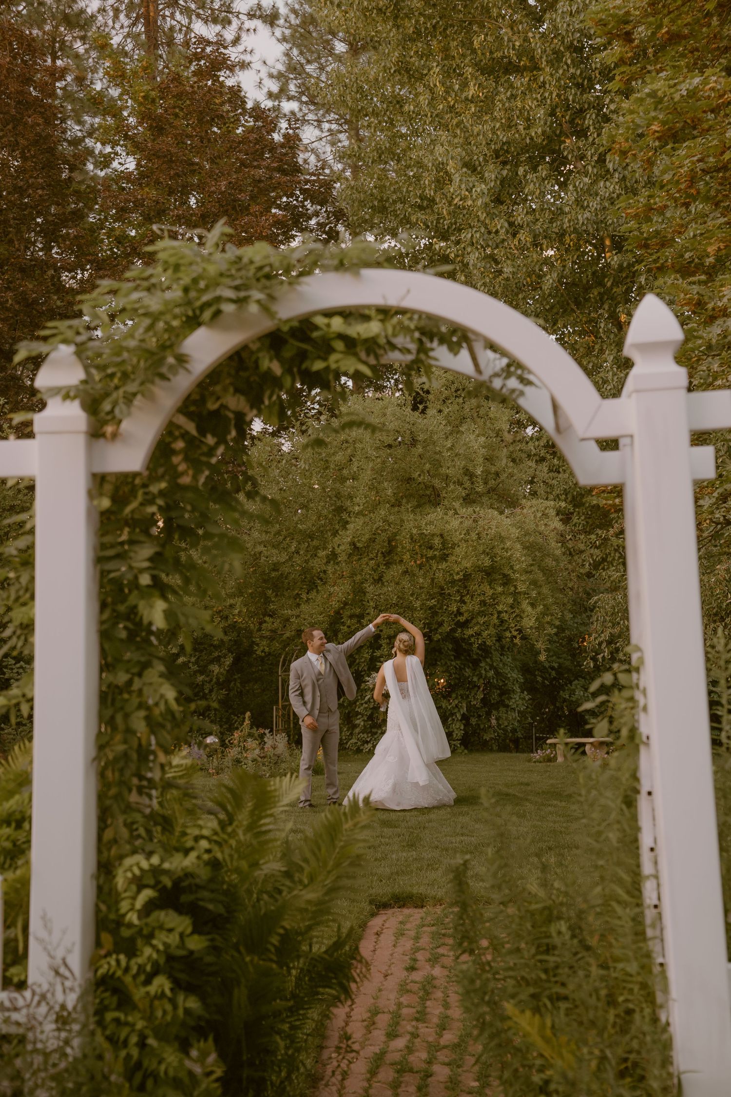 Garden wedding ceremony site with white picket fence and archway.