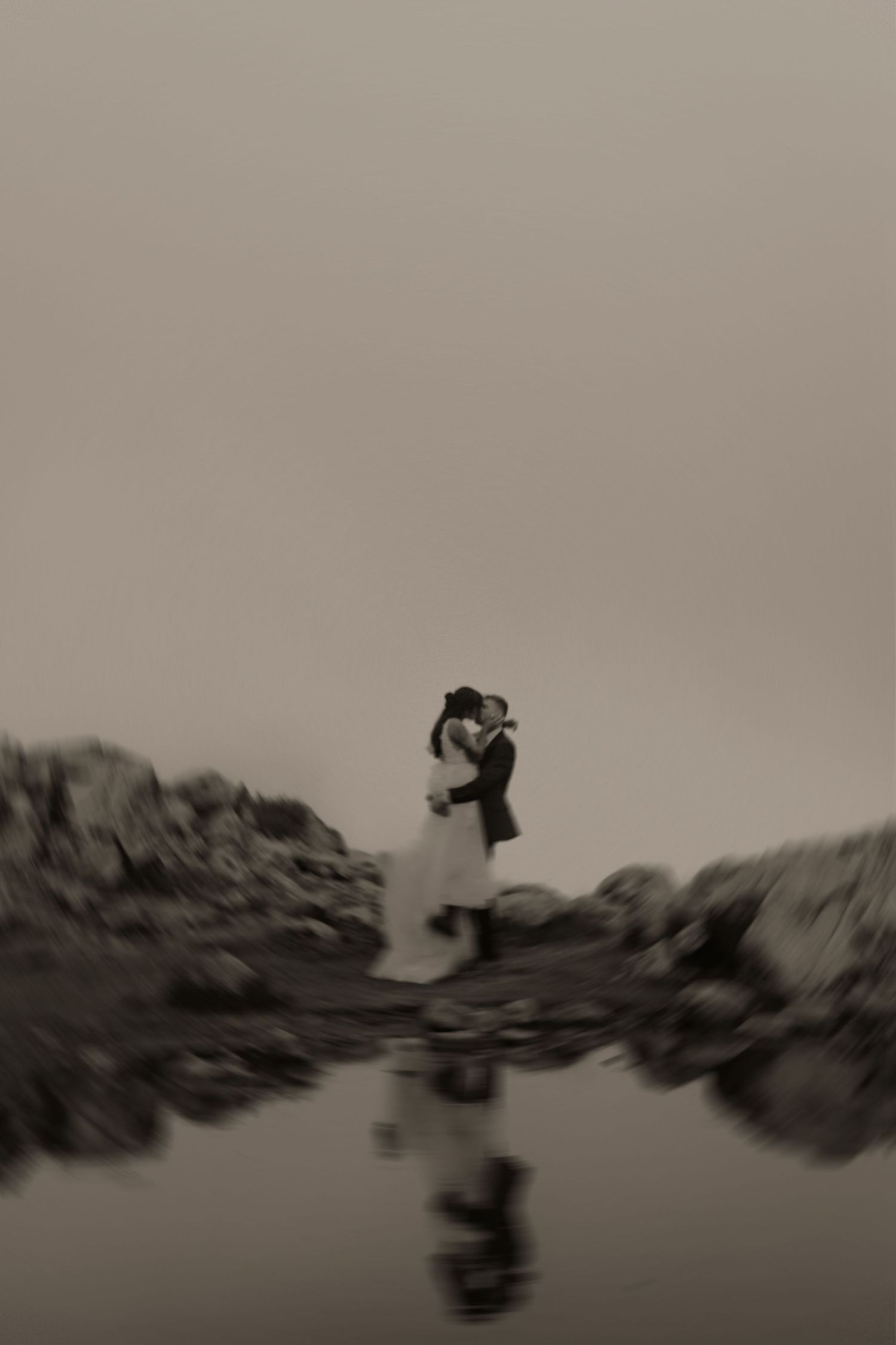 A sequence of silhouettes jumping across rocky terrain in black and white photography creates a dynamic panoramic effect.