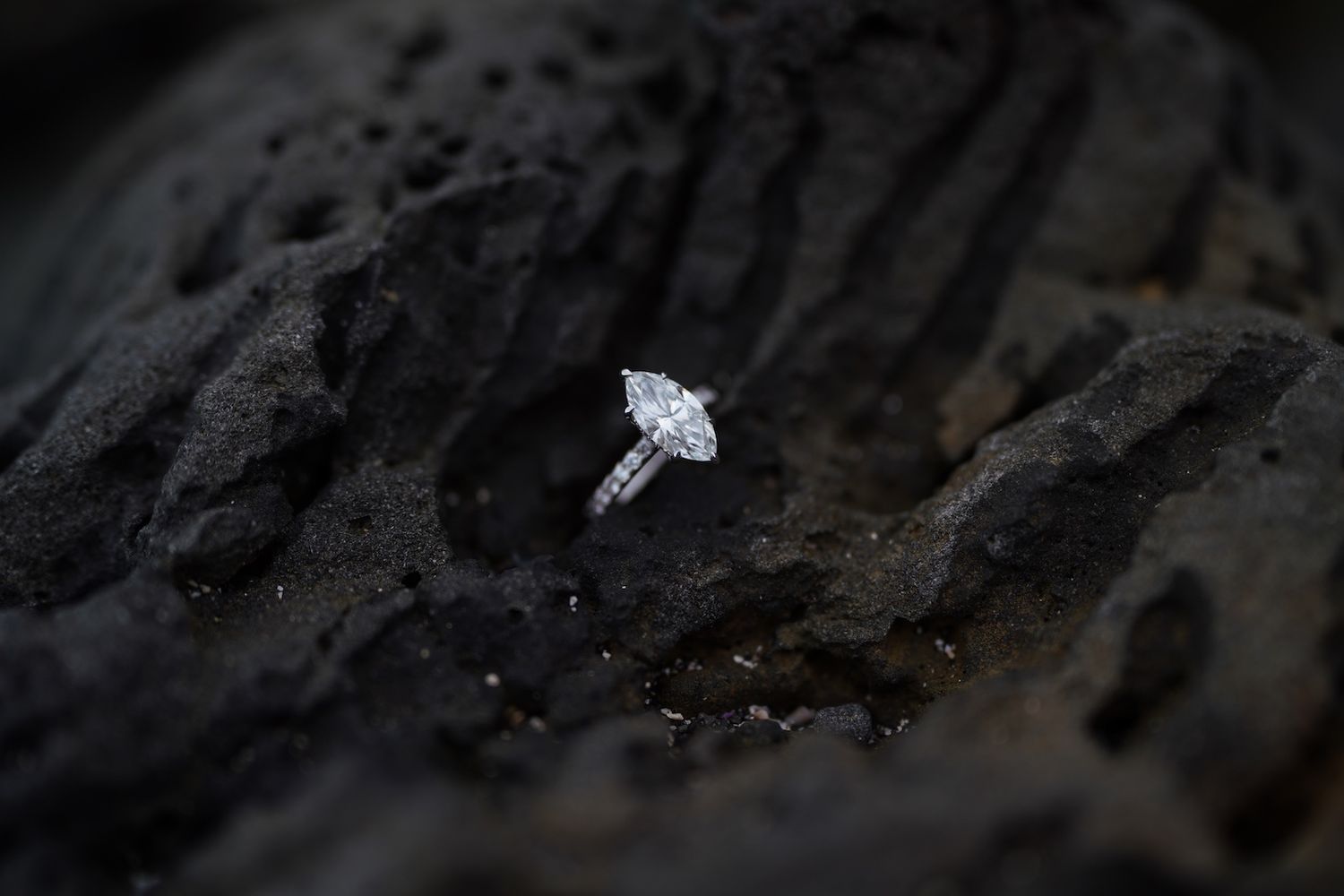 Engagement ring on volcanic rock.