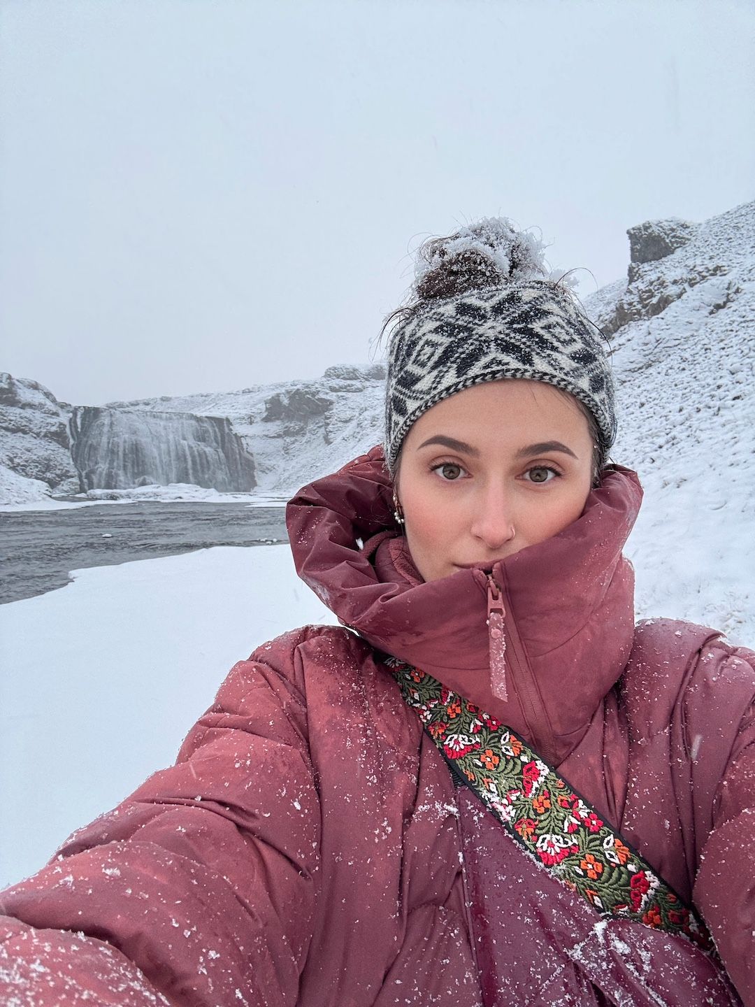 Professional elopement photographer at Þórufoss waterfall in Iceland during winter