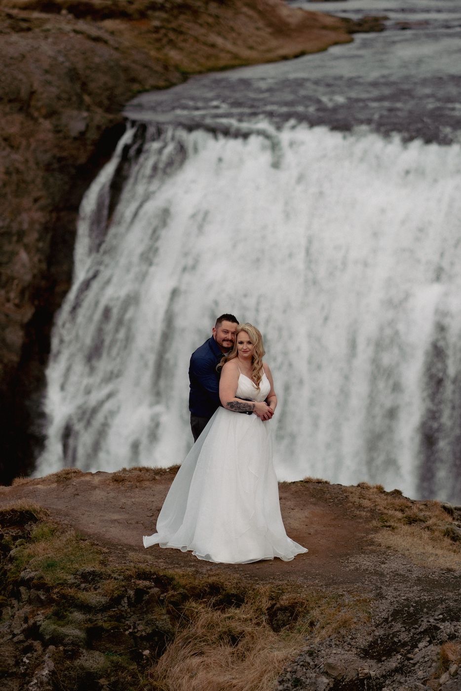 Married couple hugging in front of Thorufoss