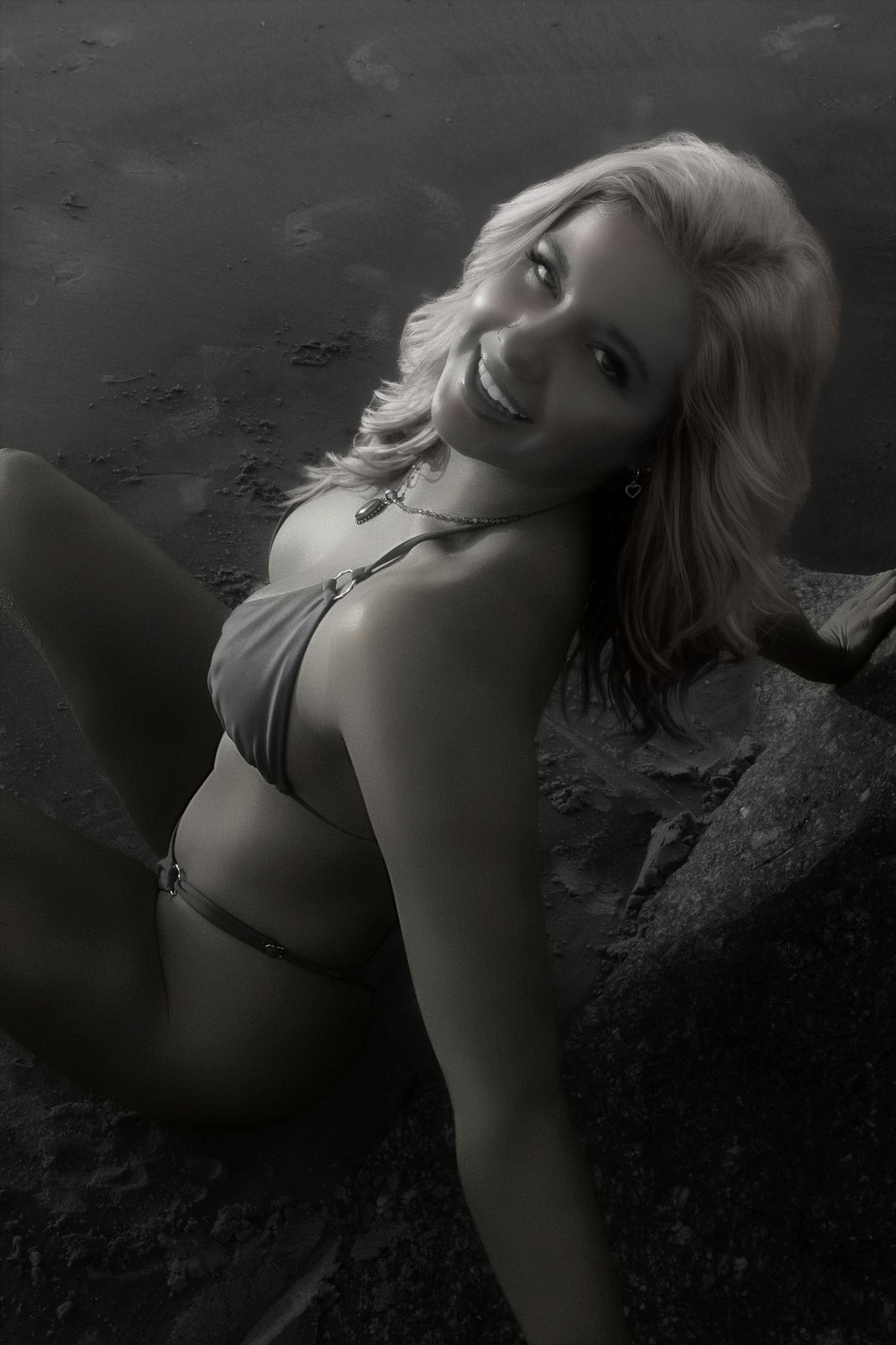 Artistic black and white portrait of a person in swimwear posing on dark rocks with dramatic lighting and shadows.