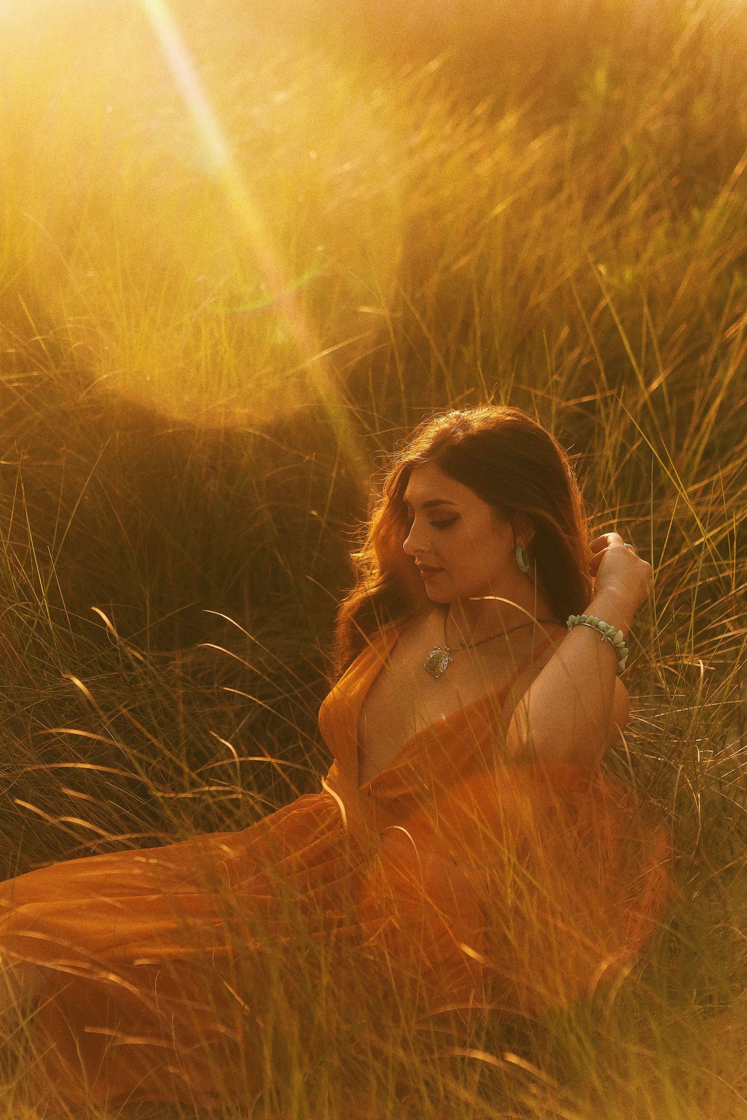 Ethereal sunset portrait series of figures laying in golden grass with warm glowing light and dreamy atmosphere.