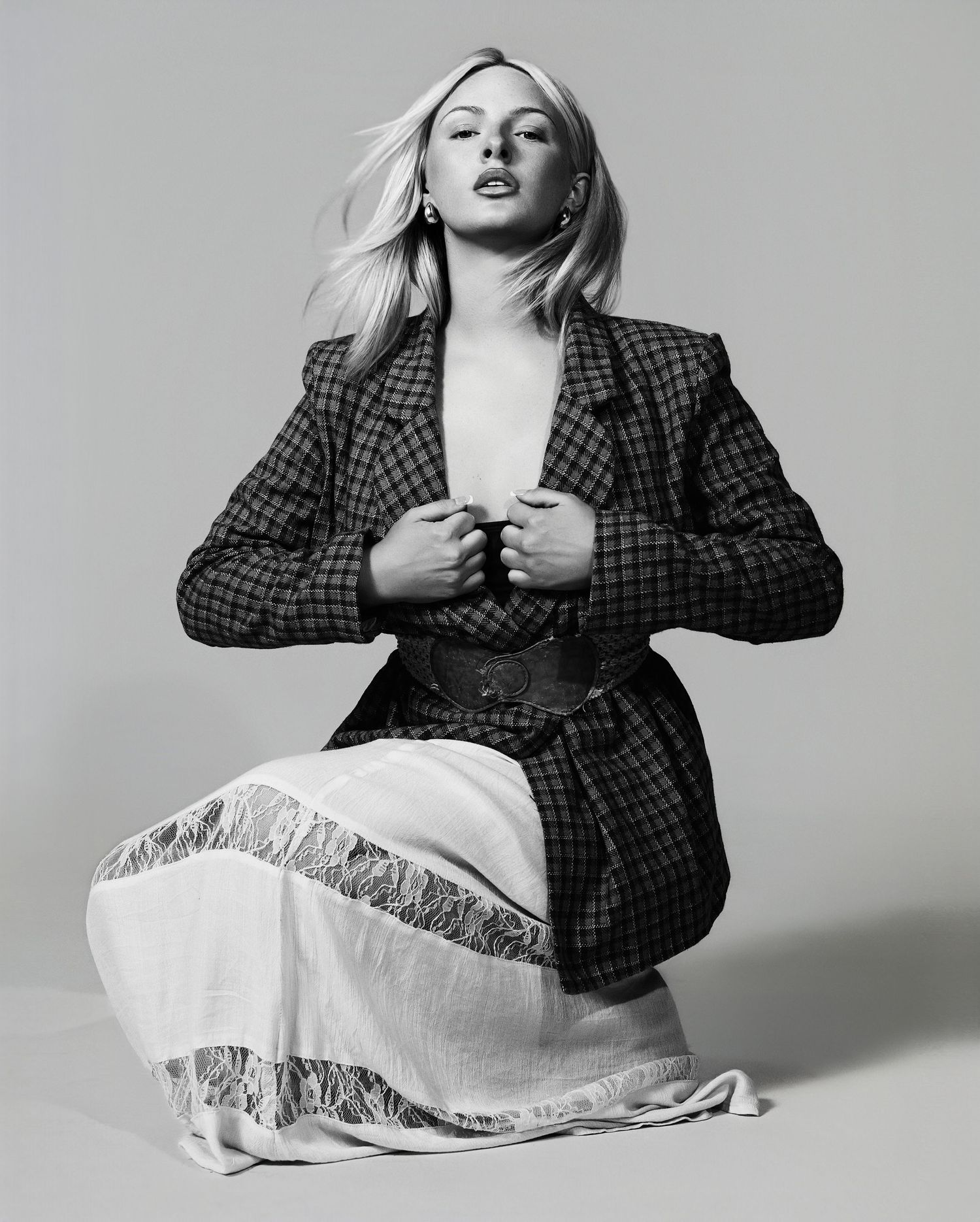 A series of fashion photos showing someone posing in a plaid blazer against a gray backdrop.