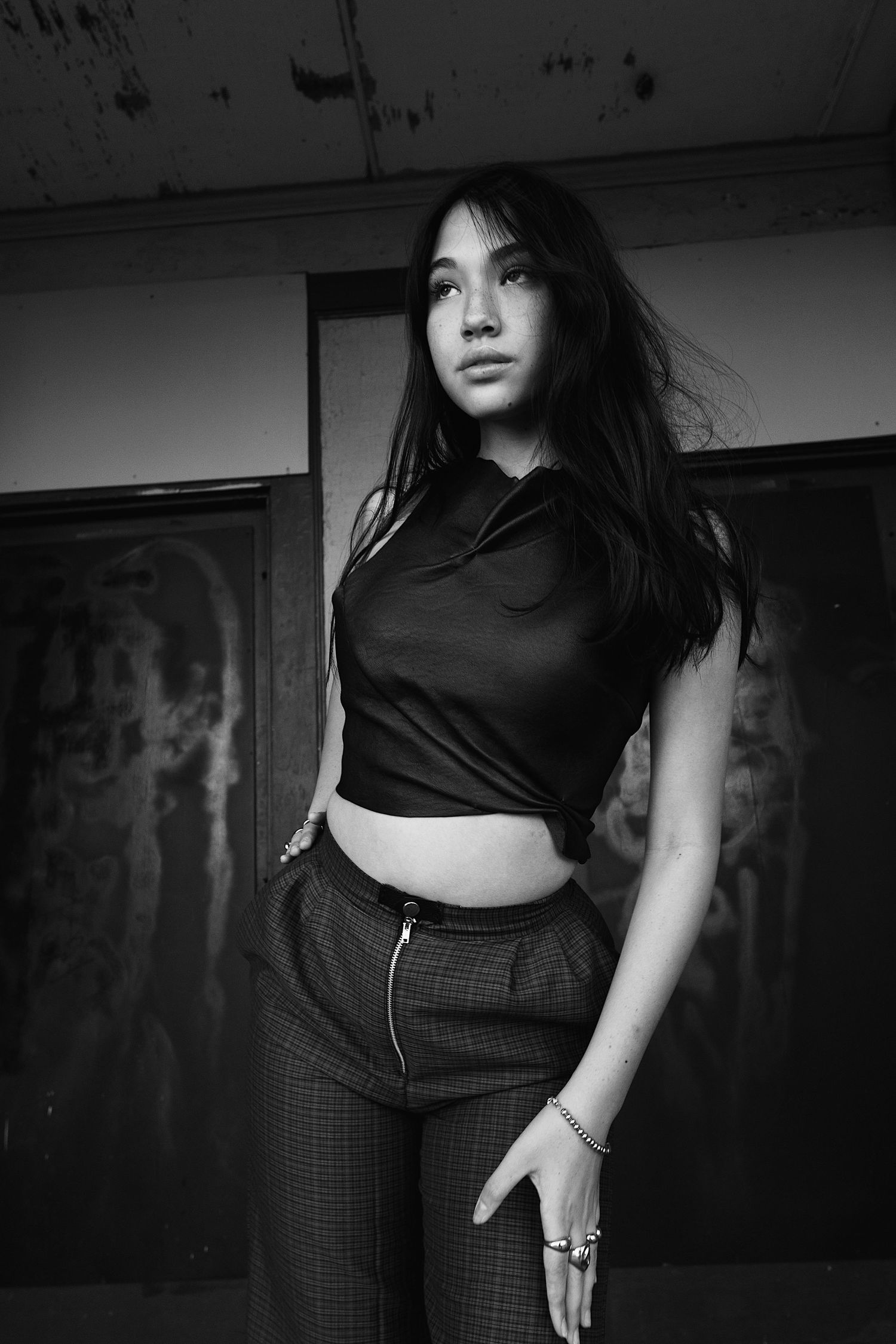 Black and white artistic self-portrait series showing cropped fashion shots of a person in dark clothing against a moody backdrop.