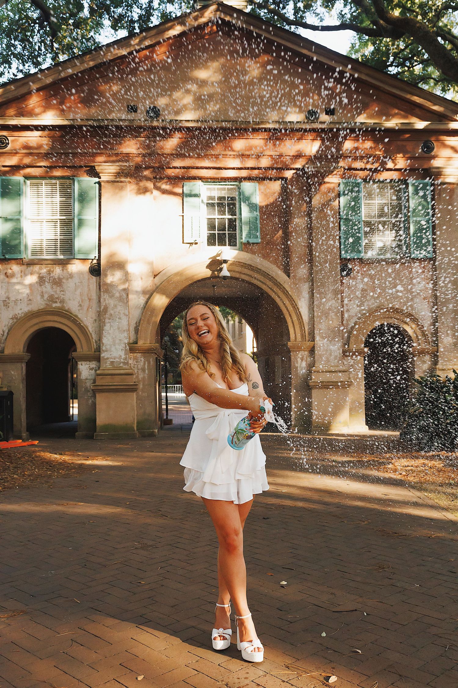 A figure dances joyfully in front of a historic stone building while sparkles of light create a magical atmosphere.