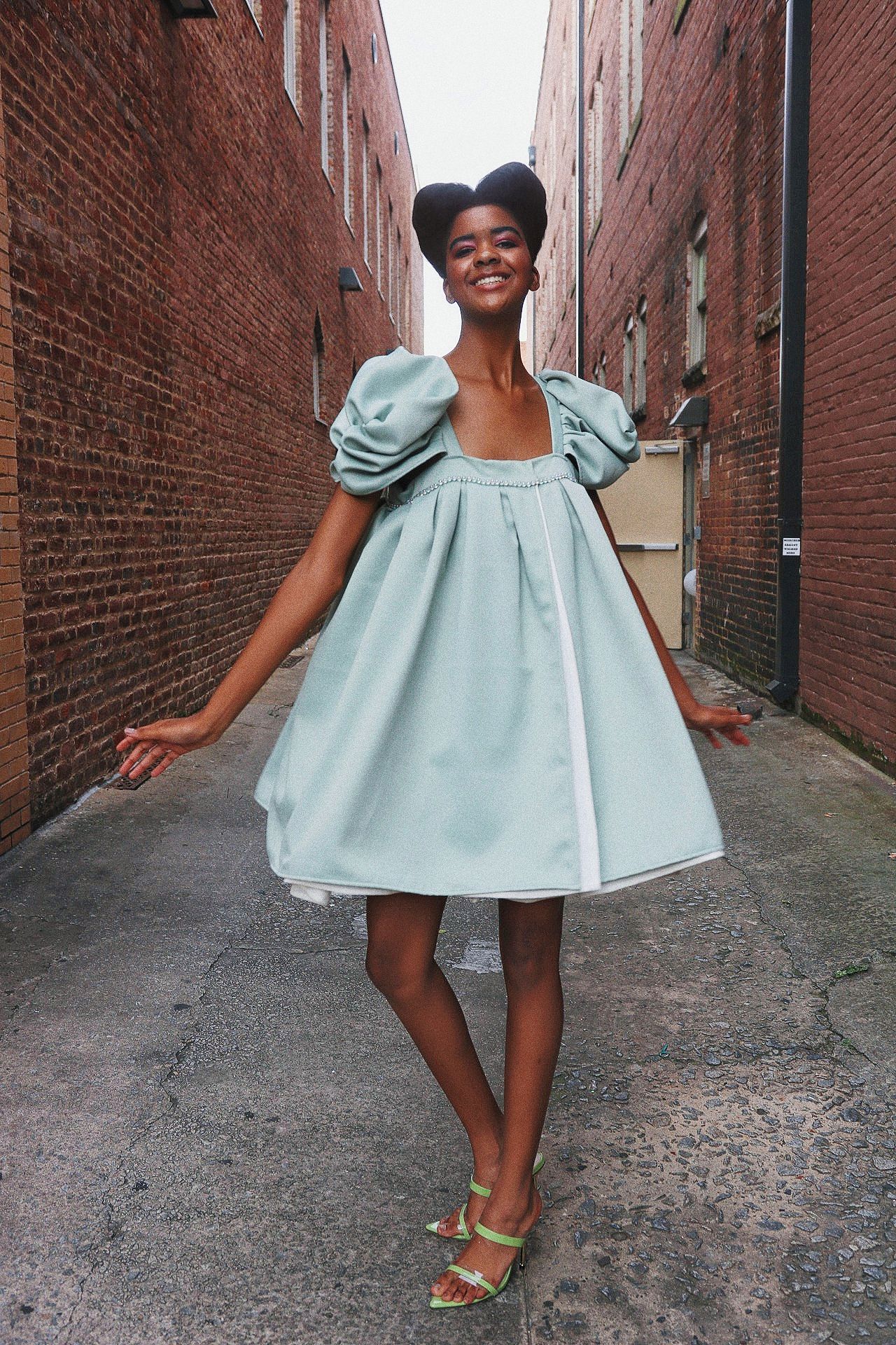 A collage showing someone in a light blue ruffled dress twirling and posing against a brick wall backdrop.