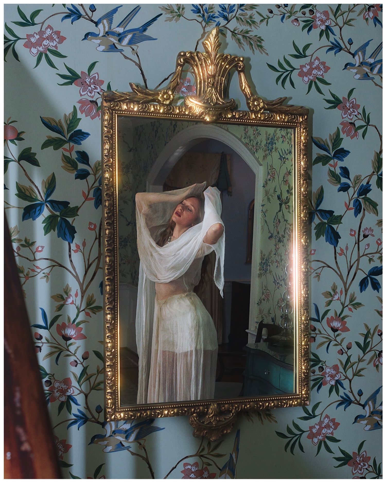 Five sequential photos showing a flowing white dress and veil reflected in an ornate gold mirror against floral wallpaper.