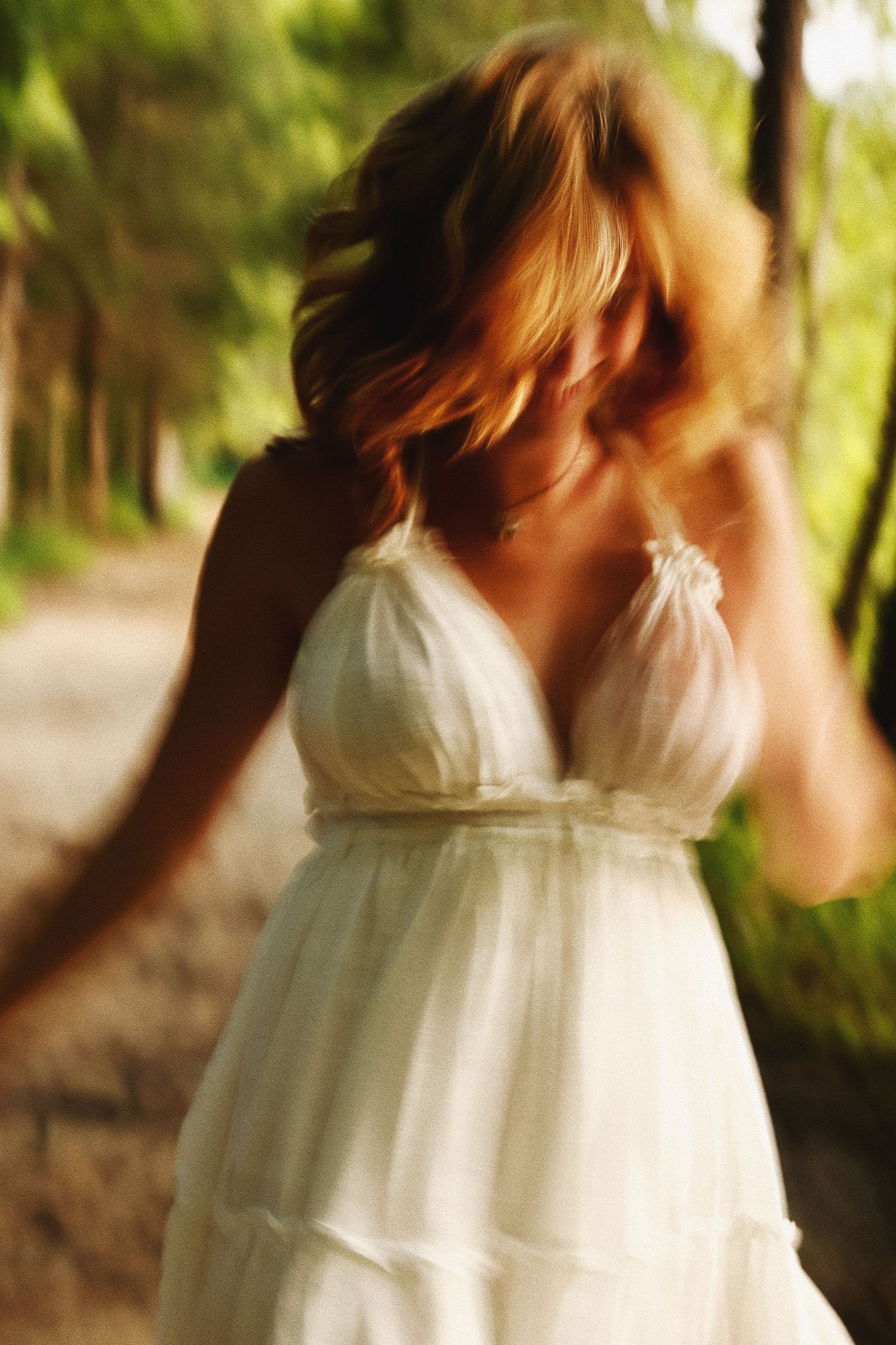 A series of motion blur photos showing a person in a flowing white dress twirling in a natural outdoor setting.