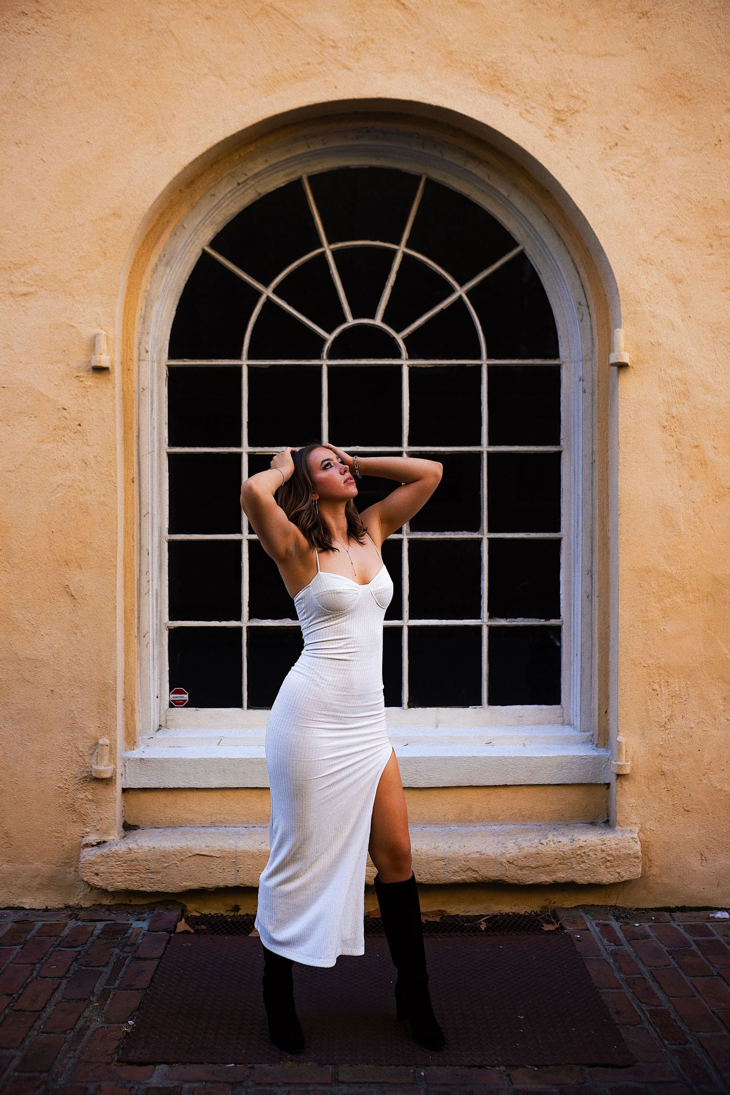 A series of four sequential photos showing a person in a white tank top looking through an arched window on a yellow wall.