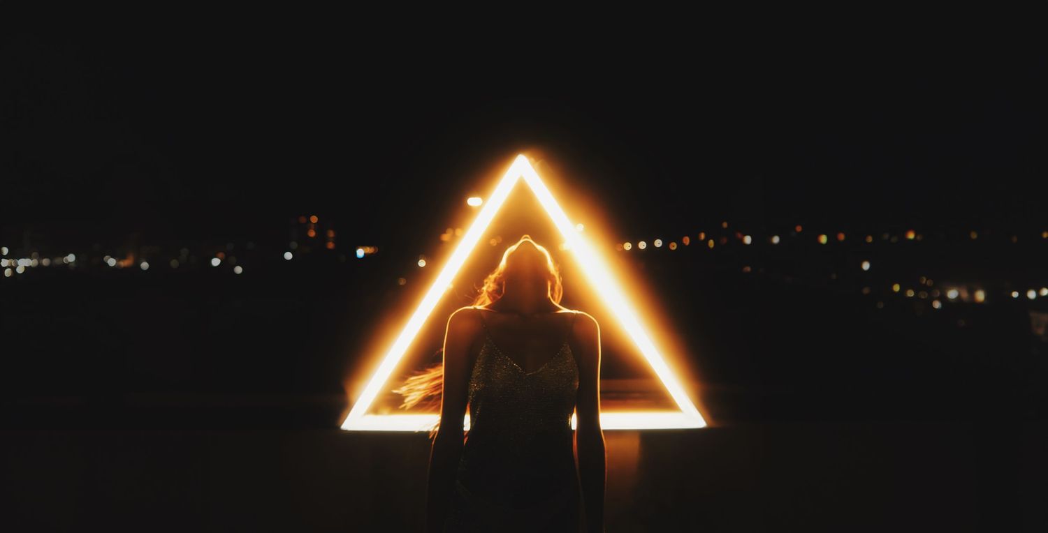 Glowing neon light triangle shapes create geometric patterns against dark background.