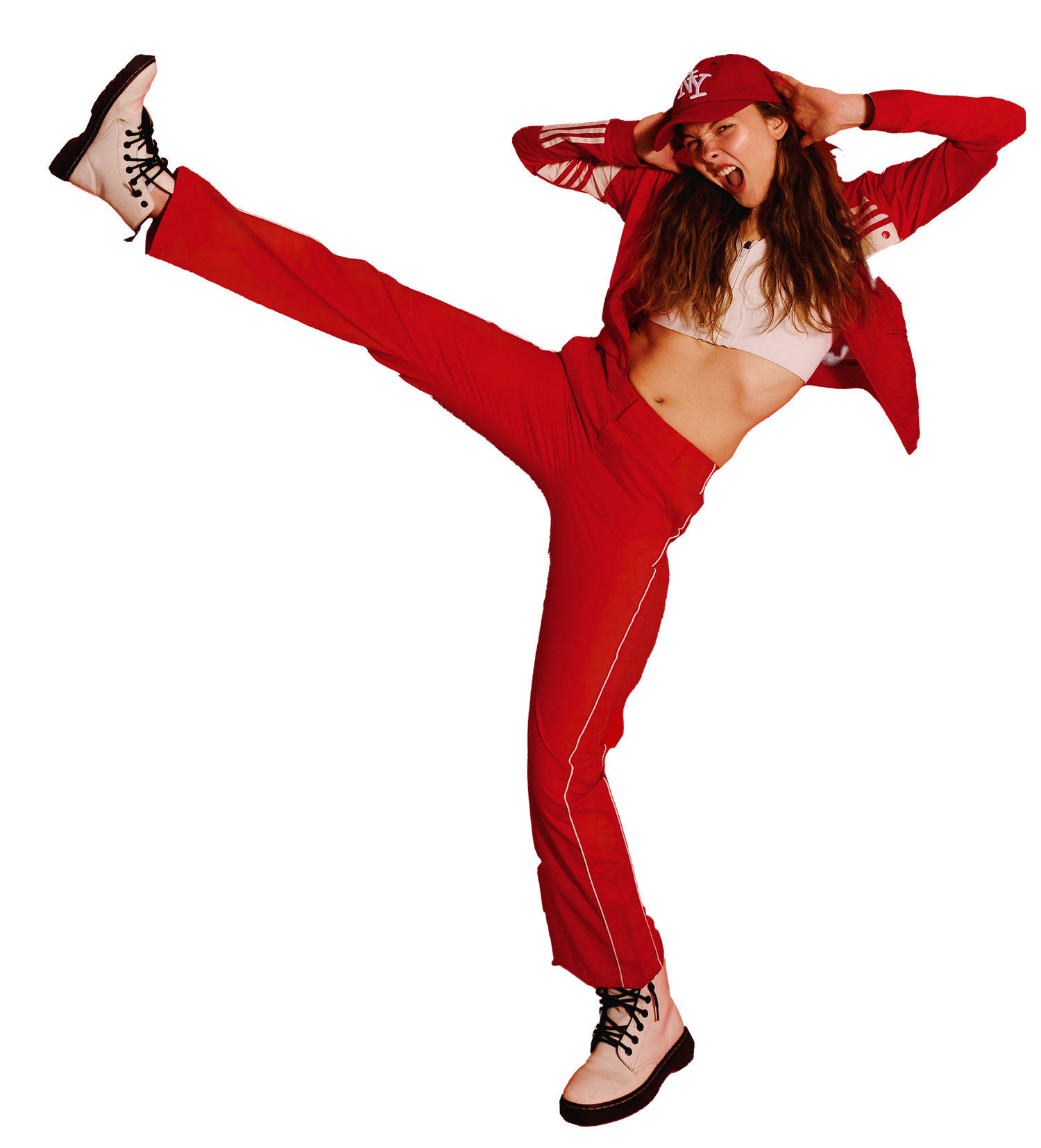 A person in a bright red tracksuit and baseball cap strikes a dynamic high-kick pose against a white background.