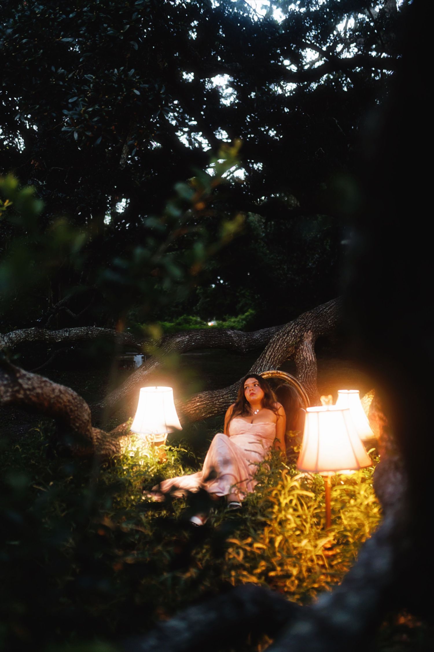 A romantic evening photoshoot in a garden with glowing lanterns creating a warm, magical atmosphere at dusk.