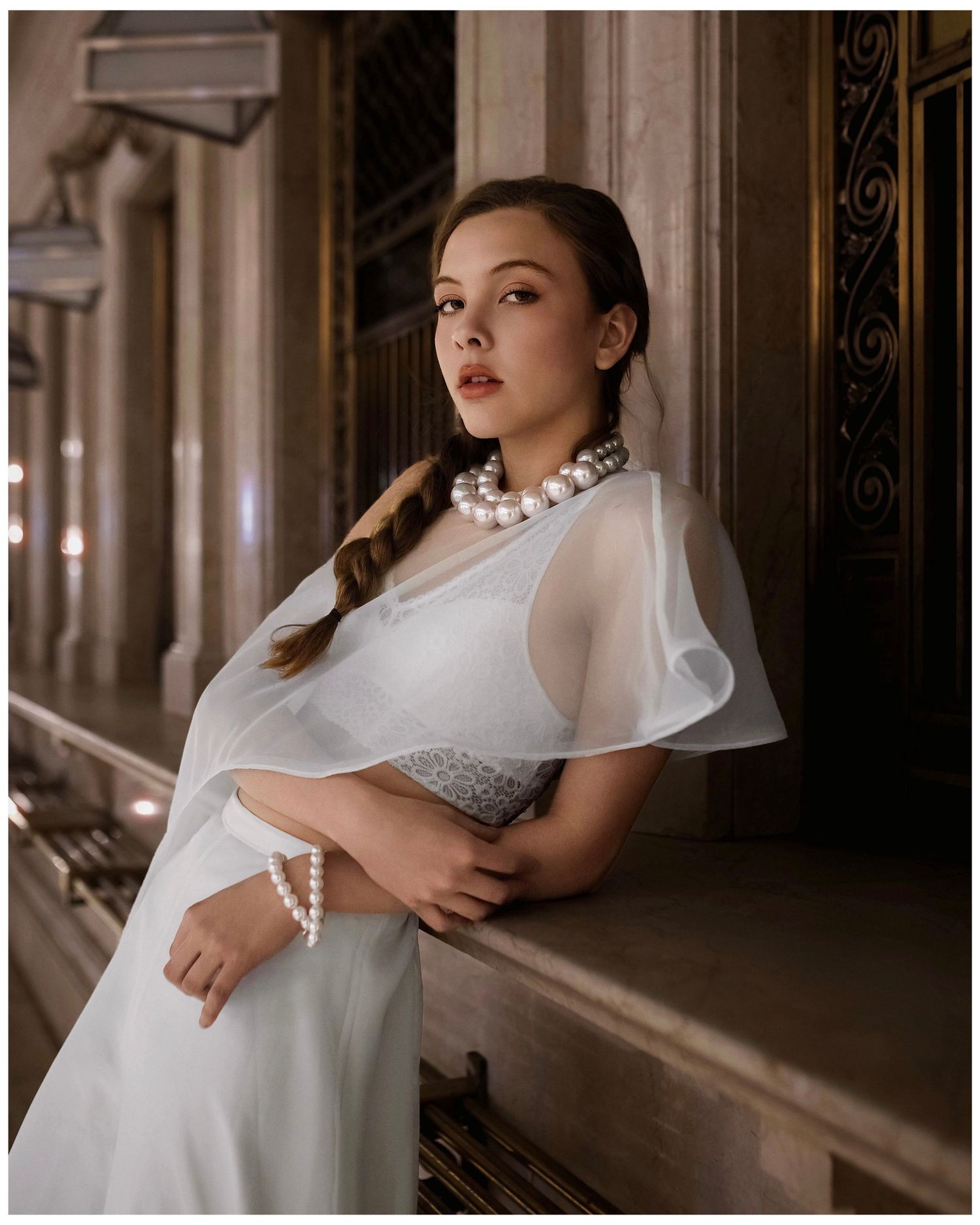 Vintage interior hallway with elegant archways, columns and natural light creating a dreamy bridal portrait atmosphere.