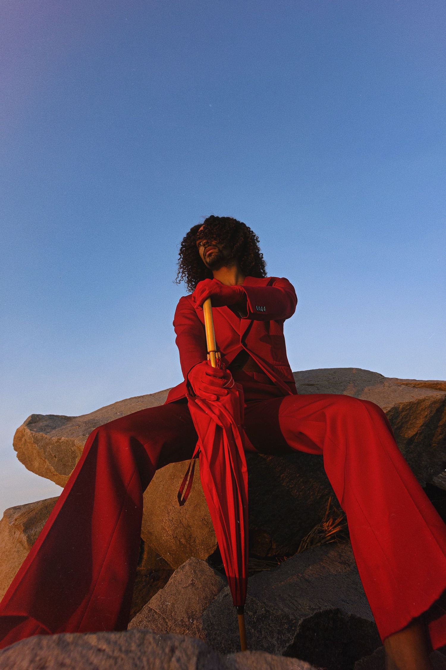 A series of images showing figures in flowing red dresses against a desert landscape at sunset.