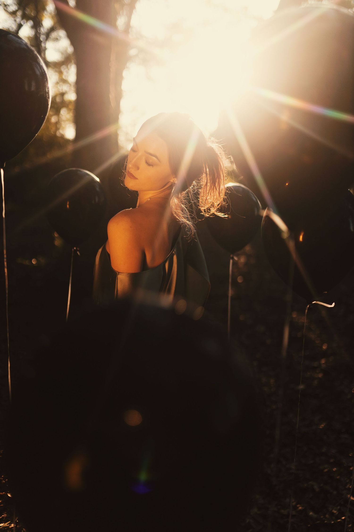 A series of ethereal backlit silhouettes with lens flares creates a dreamy atmosphere in dark outdoor setting.