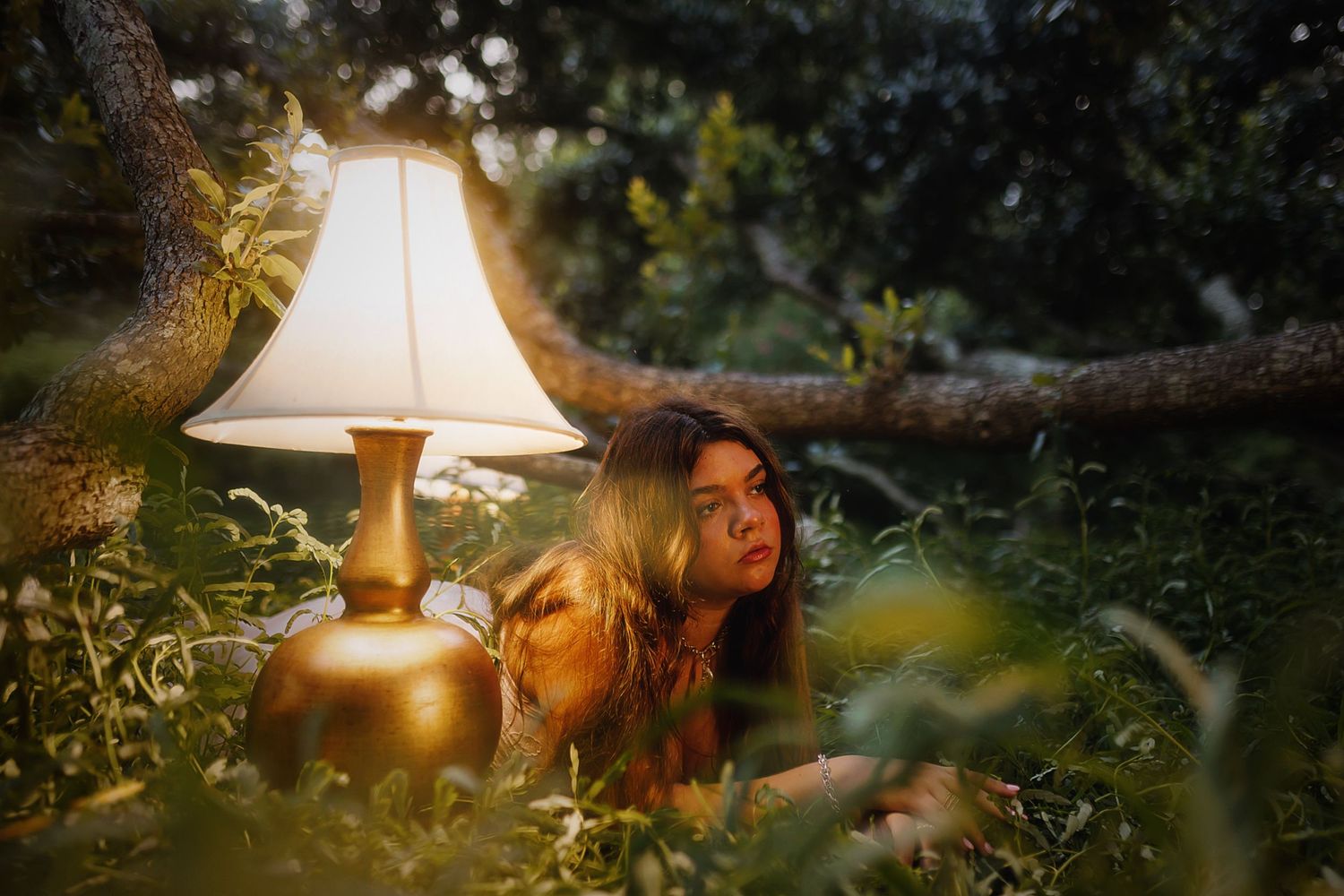 Glowing table lamp illuminates a dreamy garden scene with lush greenery at dusk.