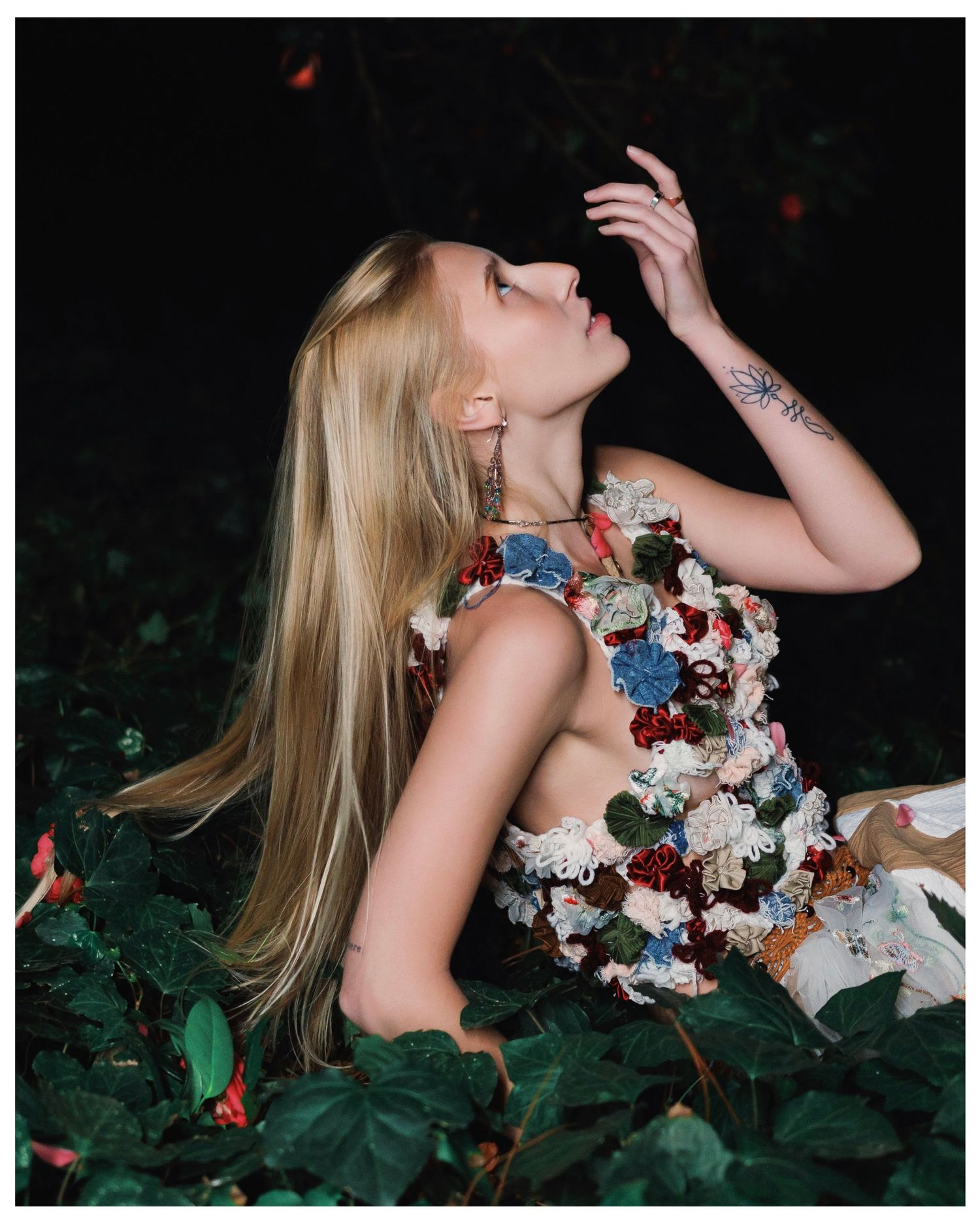 Ethereal series of portraits showing a woman in a floral dress lying among dark foliage in a dramatic outdoor setting.