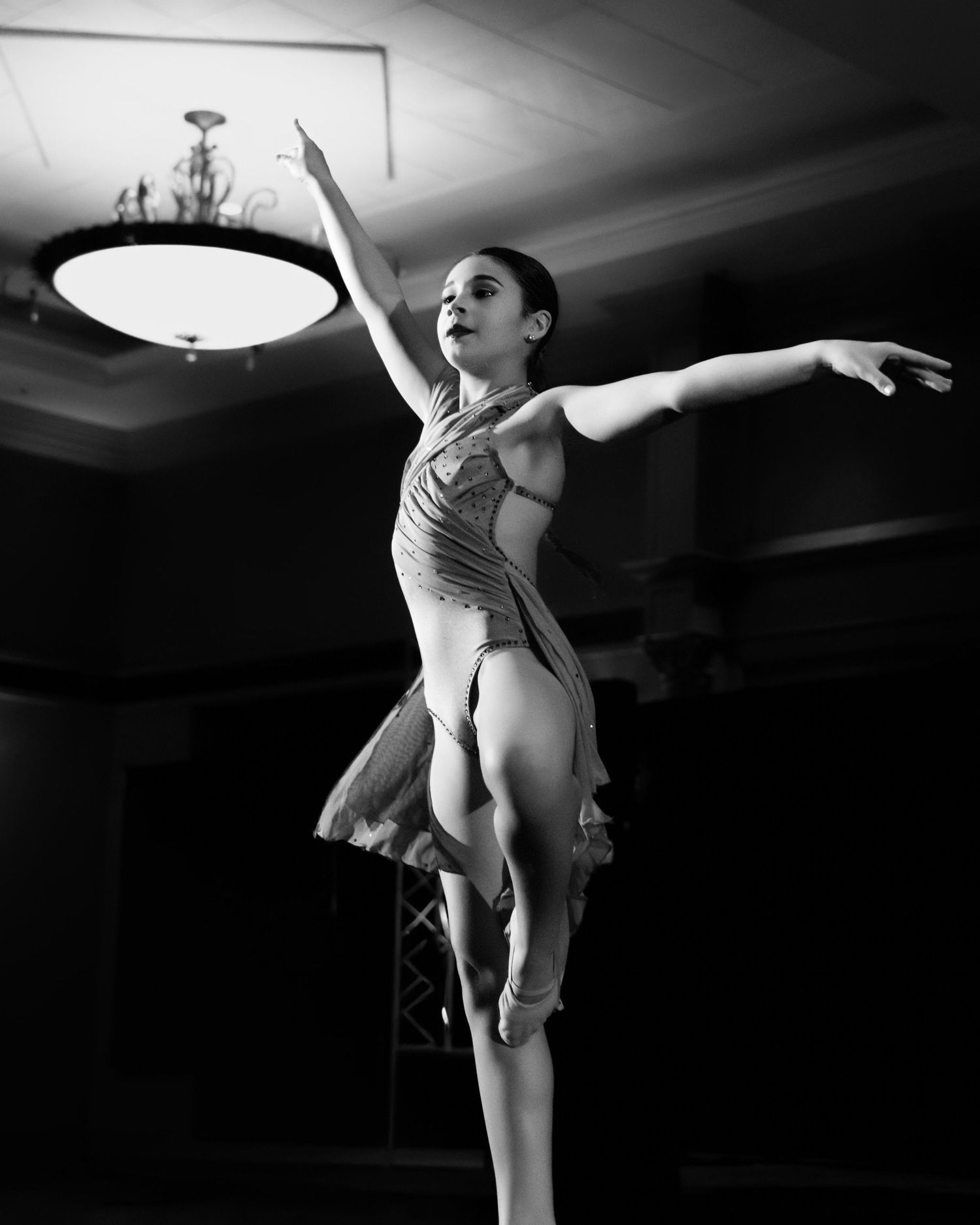 A black and white photo series shows a ballet dancer performing graceful poses and movements in dramatic lighting.