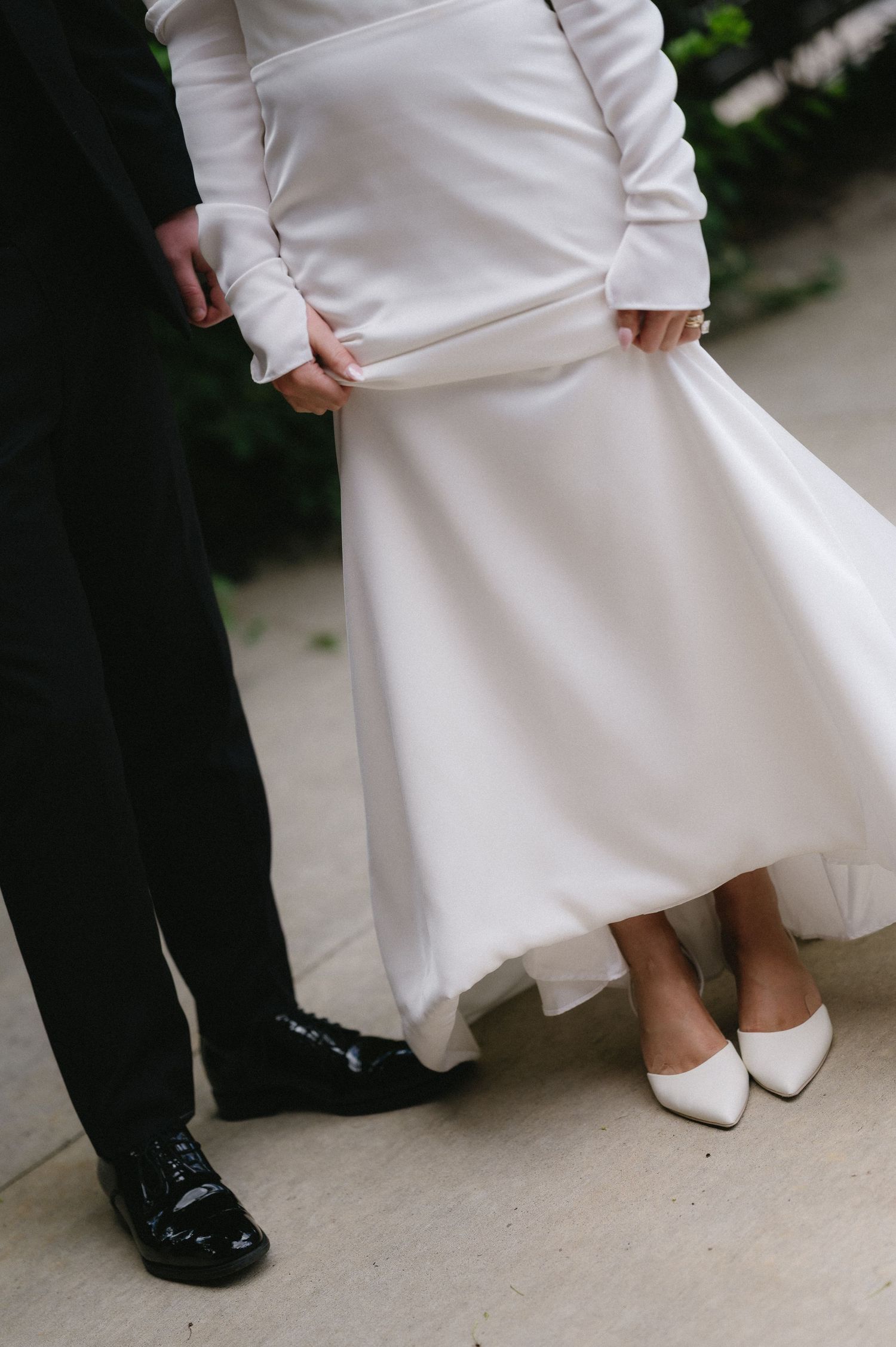 Close-up series showing contrasting black and white wedding shoes of a couple standing together on concrete.
