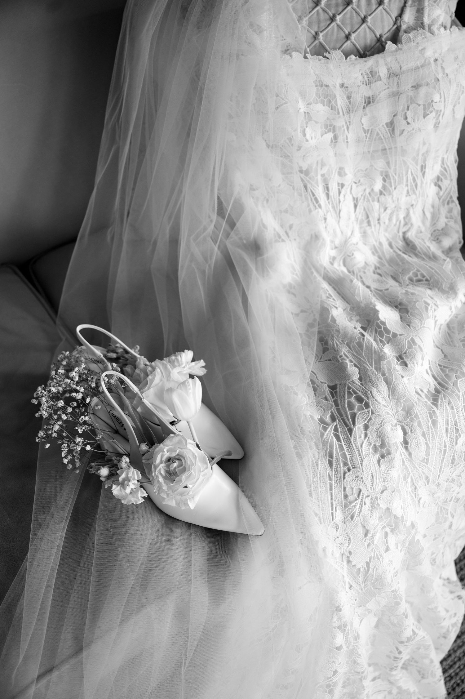 Wedding heels adorned with delicate white flowers and tulle veil details create an elegant bridal ensemble.