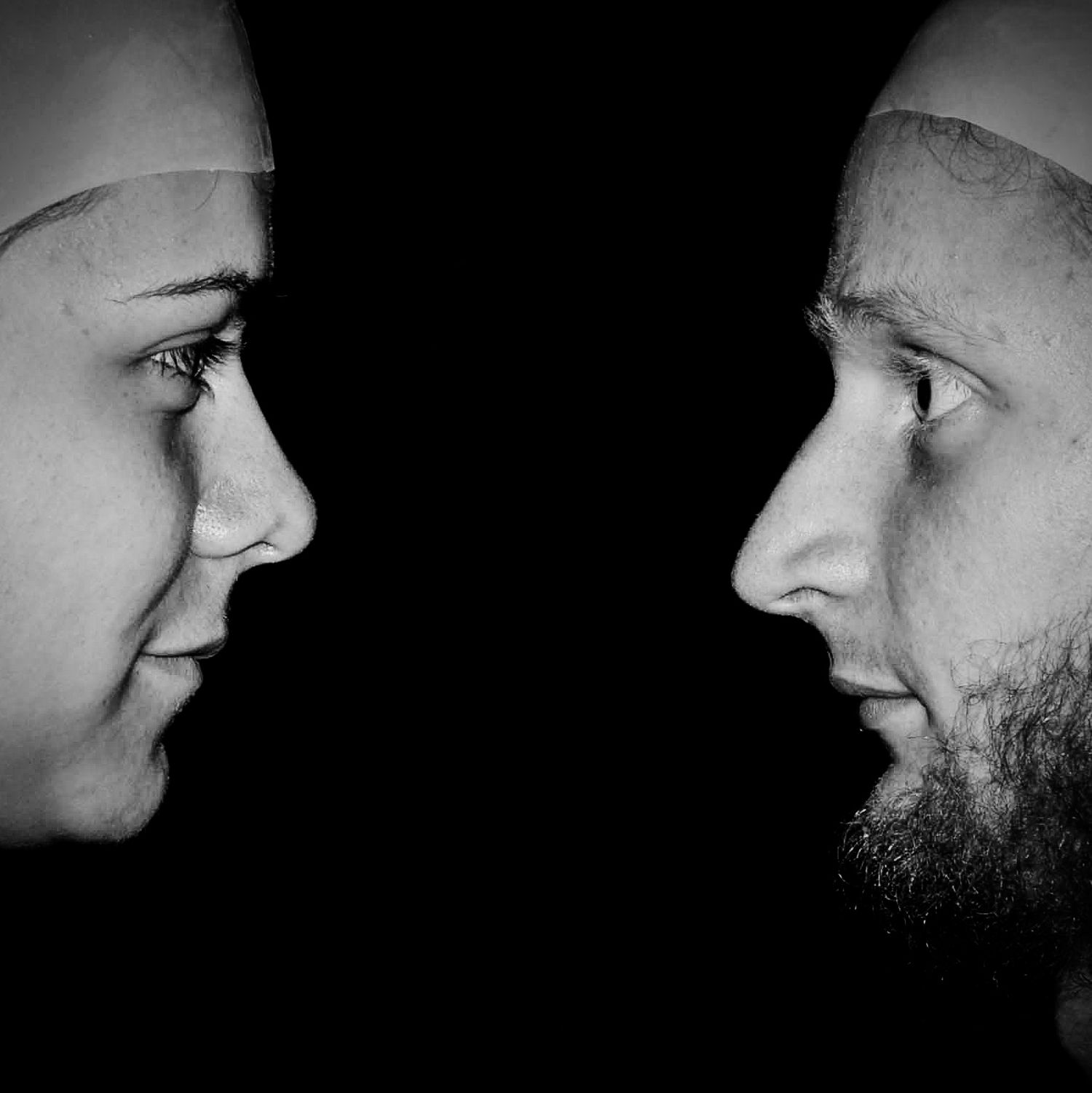 Künstlerisches Schwarz-Weiß-Portrait von Schauspielern im Profil mit intensivem Blickkontakt, dramatische Lichtführung, Theater- und Porträt