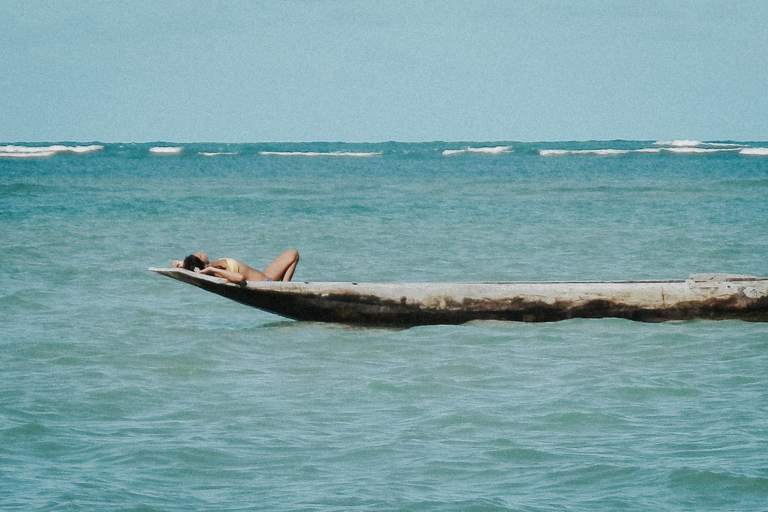 Reisefotografie von Jenny Jacoby: Person entspannt auf Boot im türkisfarbenen Meer vor der Küste Brasiliens.