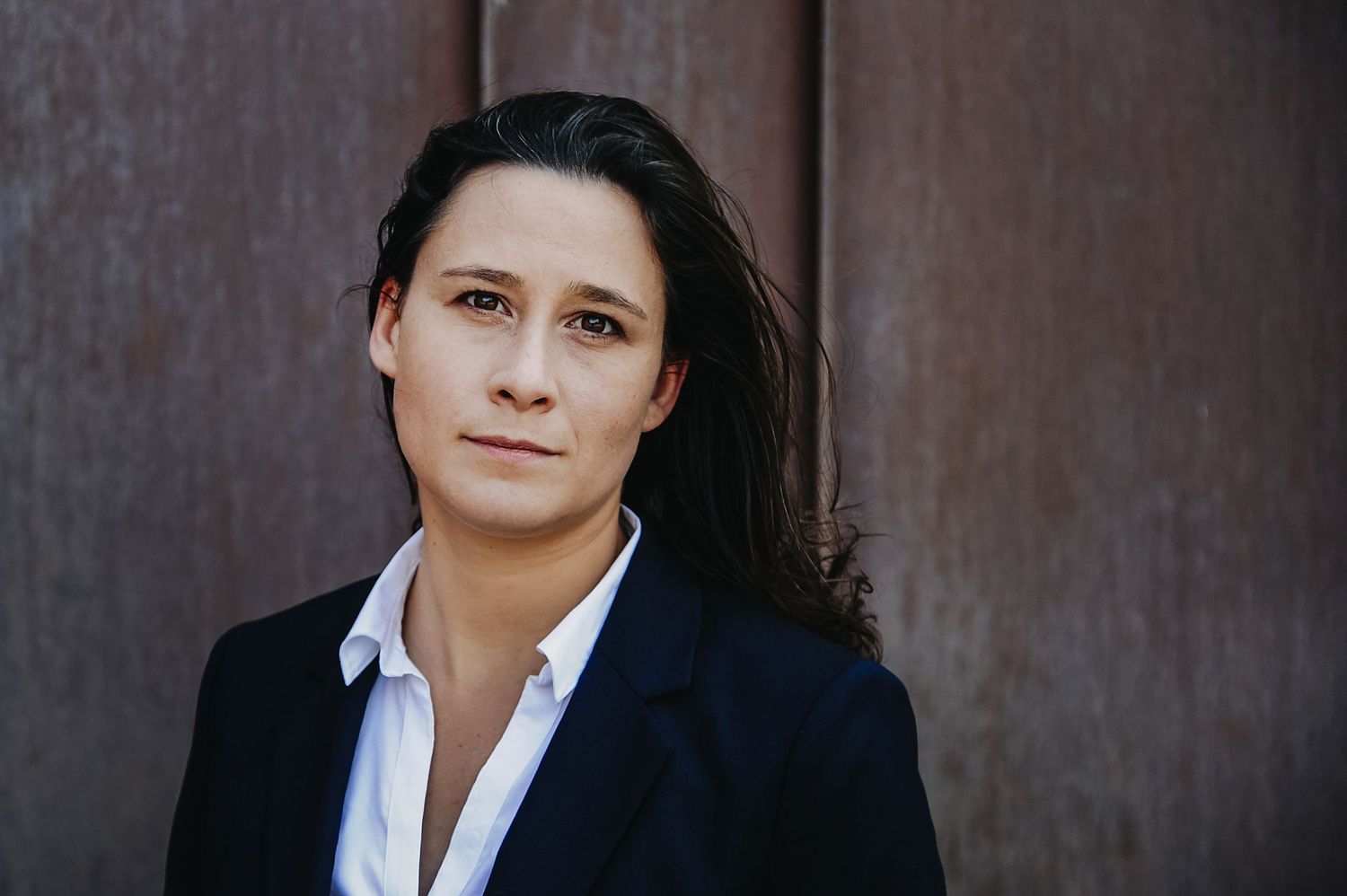 Professionelles Business-Porträt im Anzug vor industrieller Wand, fotografiert von Jenny Jacoby