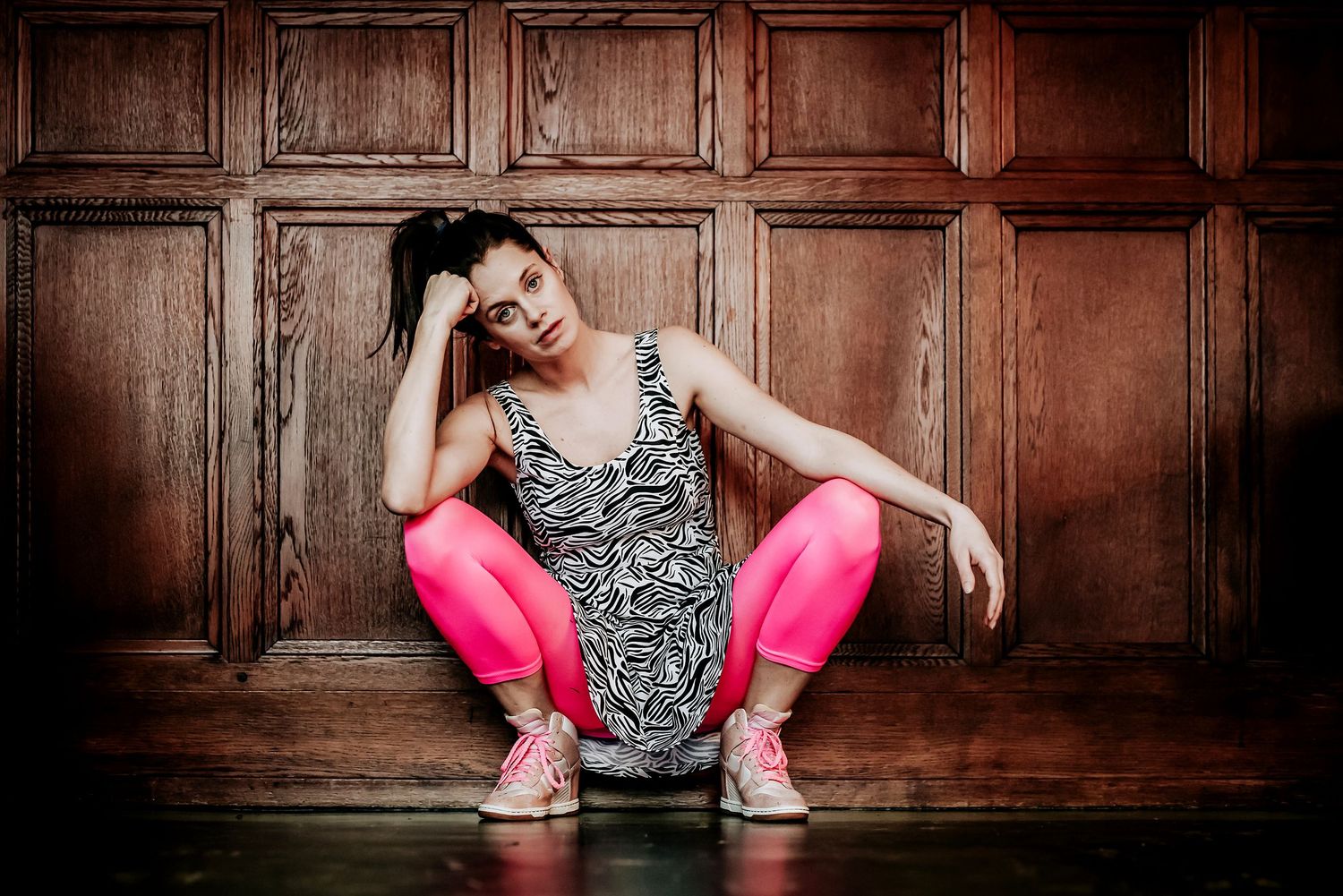 Schauspielerin Tini Lazar in pinker Leggings vor Holztäfelung, professionelles Schauspielporträt von Jenny Jacoby