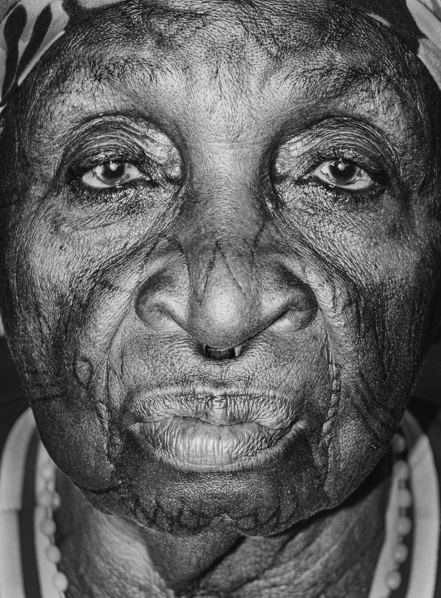 „Ausdrucksstarkes Porträt einer Makonde-Frau in Dar es Salaam, Tansania – Nahaufnahme mit feinen Gesichtszügen, traditioneller Tätowierung
