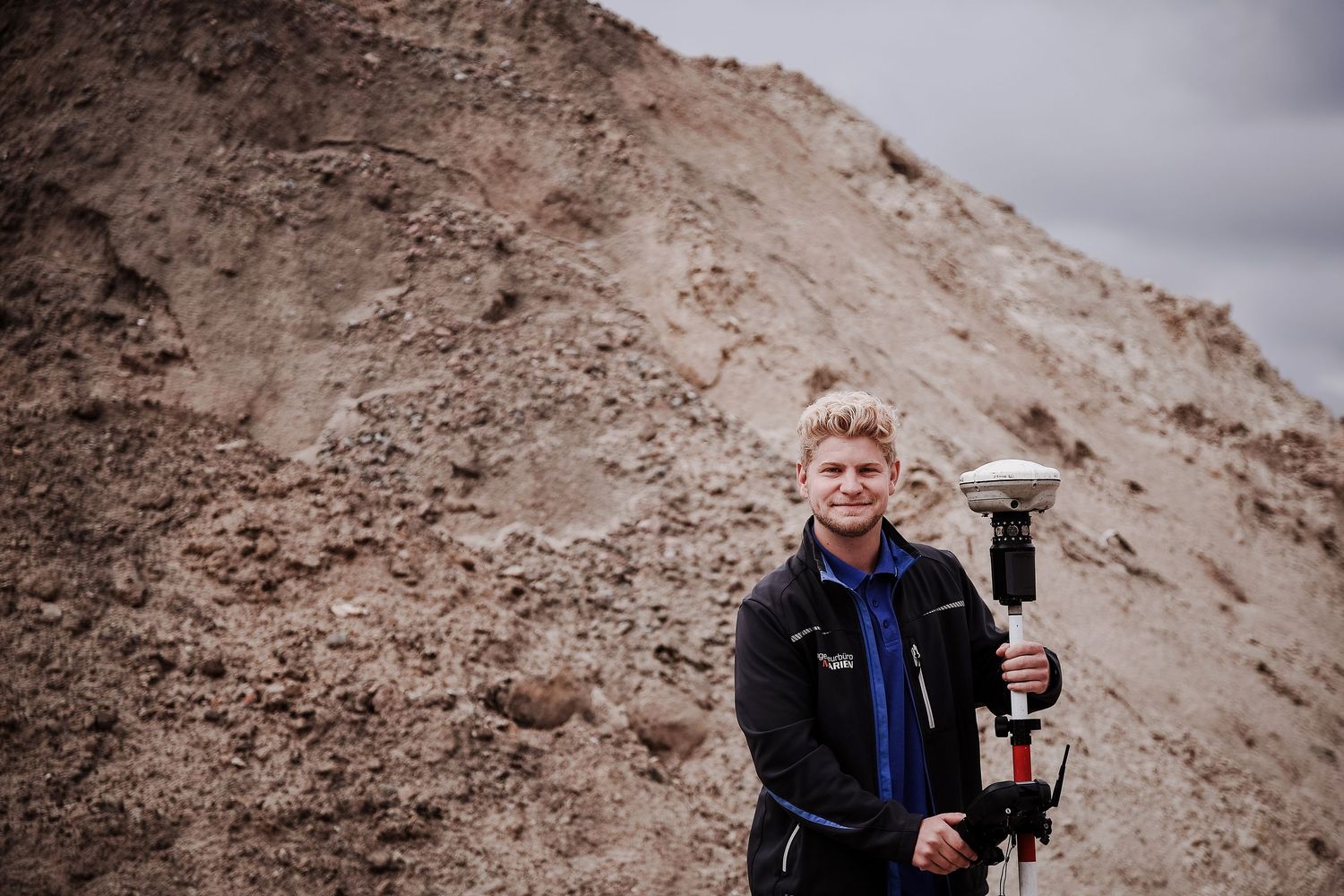 Ingenieur mit GPS-Vermessungsgerät vor Erdhügel, Vermessungstechnik und Geländeaufnahme für Ingenieursbüro Hamburg foto von Jenny Jacoby