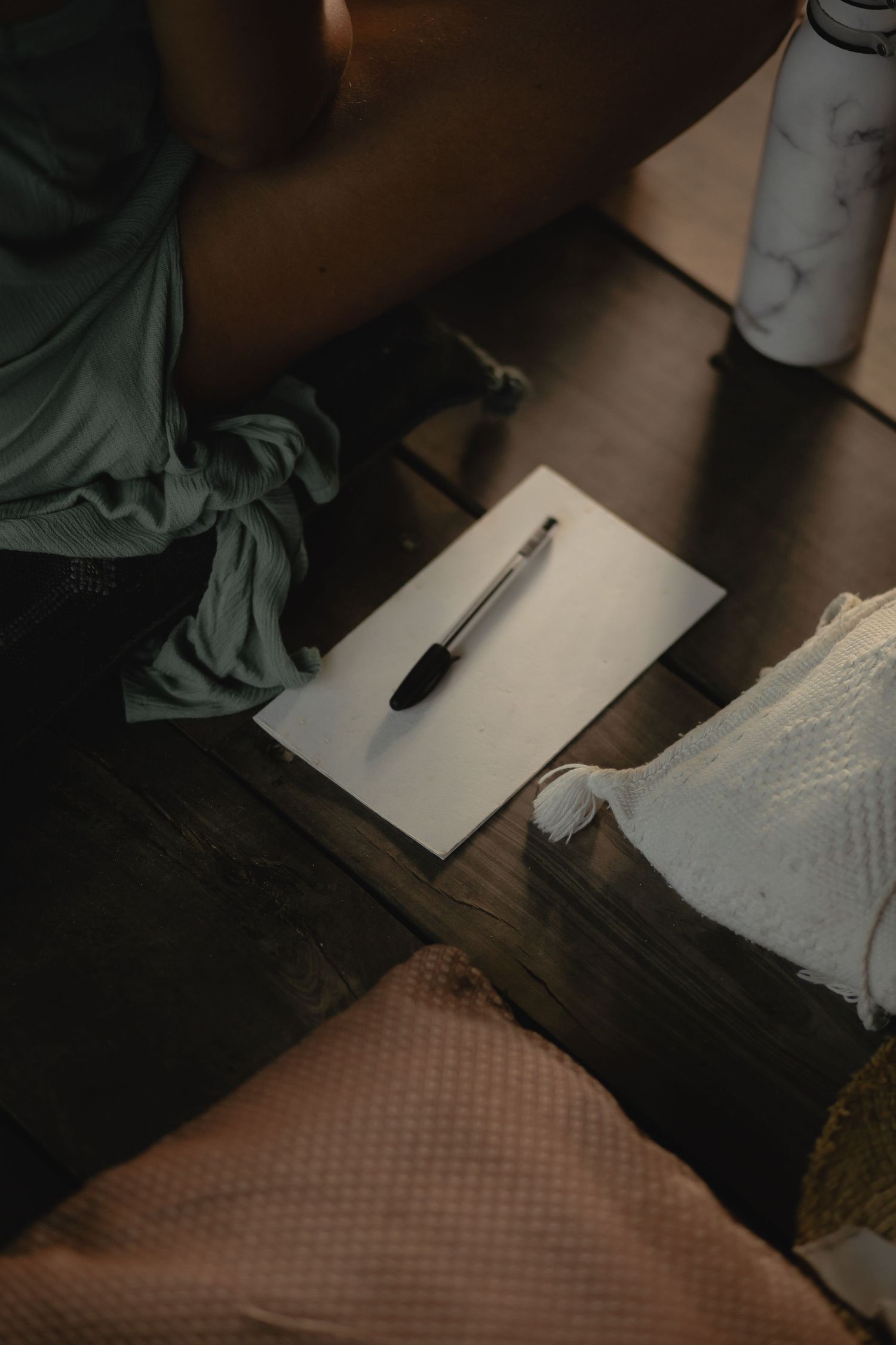 A sequence of cropped photos showing someone writing on paper at a desk in dim lighting conditions.