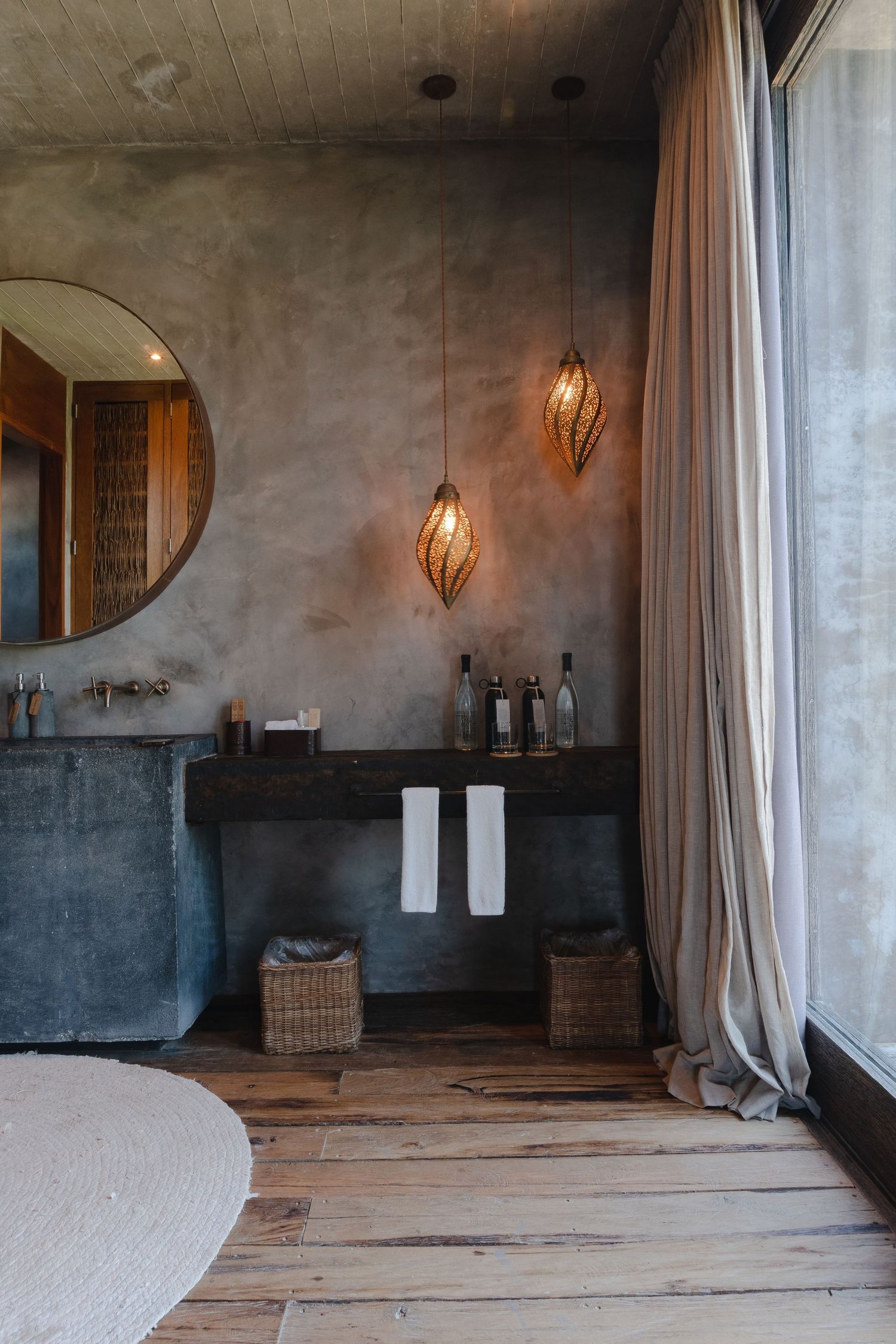 Modern spa interior with rustic wooden floors, concrete walls, and elegant pendant lighting creates a serene atmosphere.