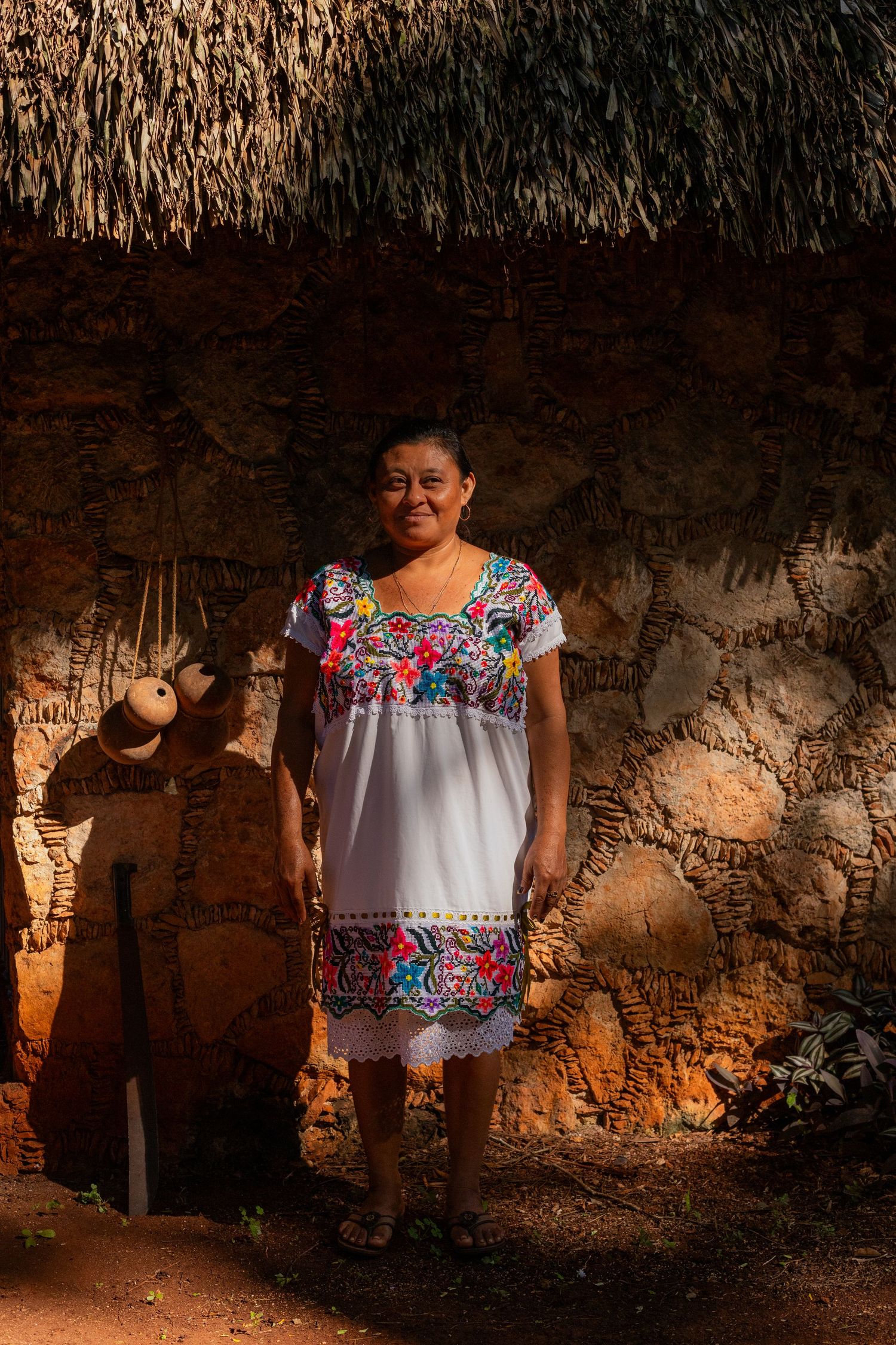 Traditional Yucatan house interior with stone walls illuminated by natural golden sunlight.