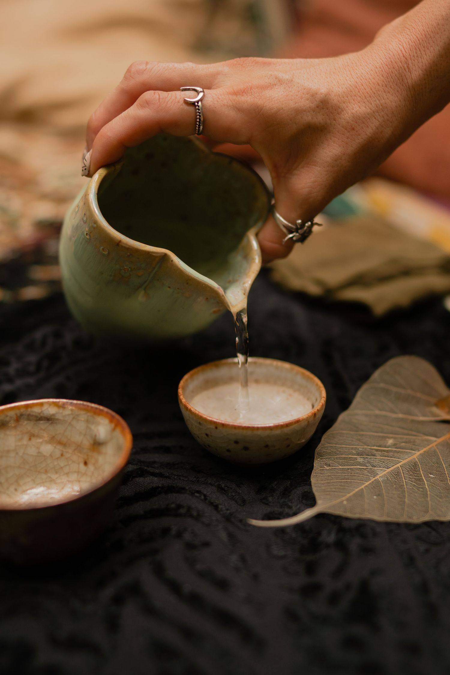 Pouring a white liquid into a rustic ceramic bowl in a series of sequential shots against a dark background.