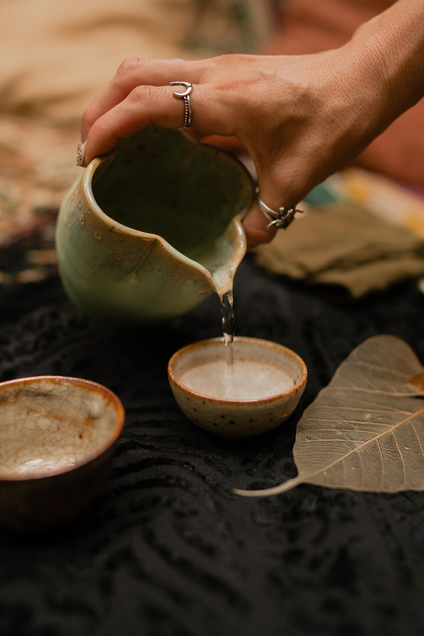 Pouring white liquid into a rustic clay bowl in a sequence of four connected images showing the pouring process.